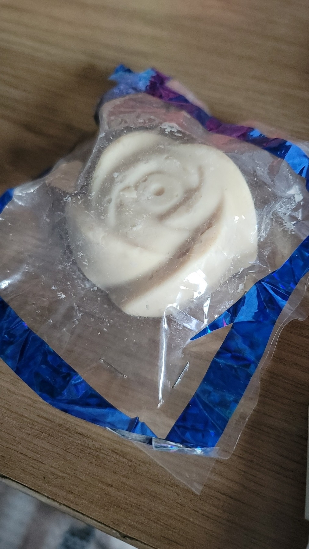 off-white circular bar of soap carved to look like a flower