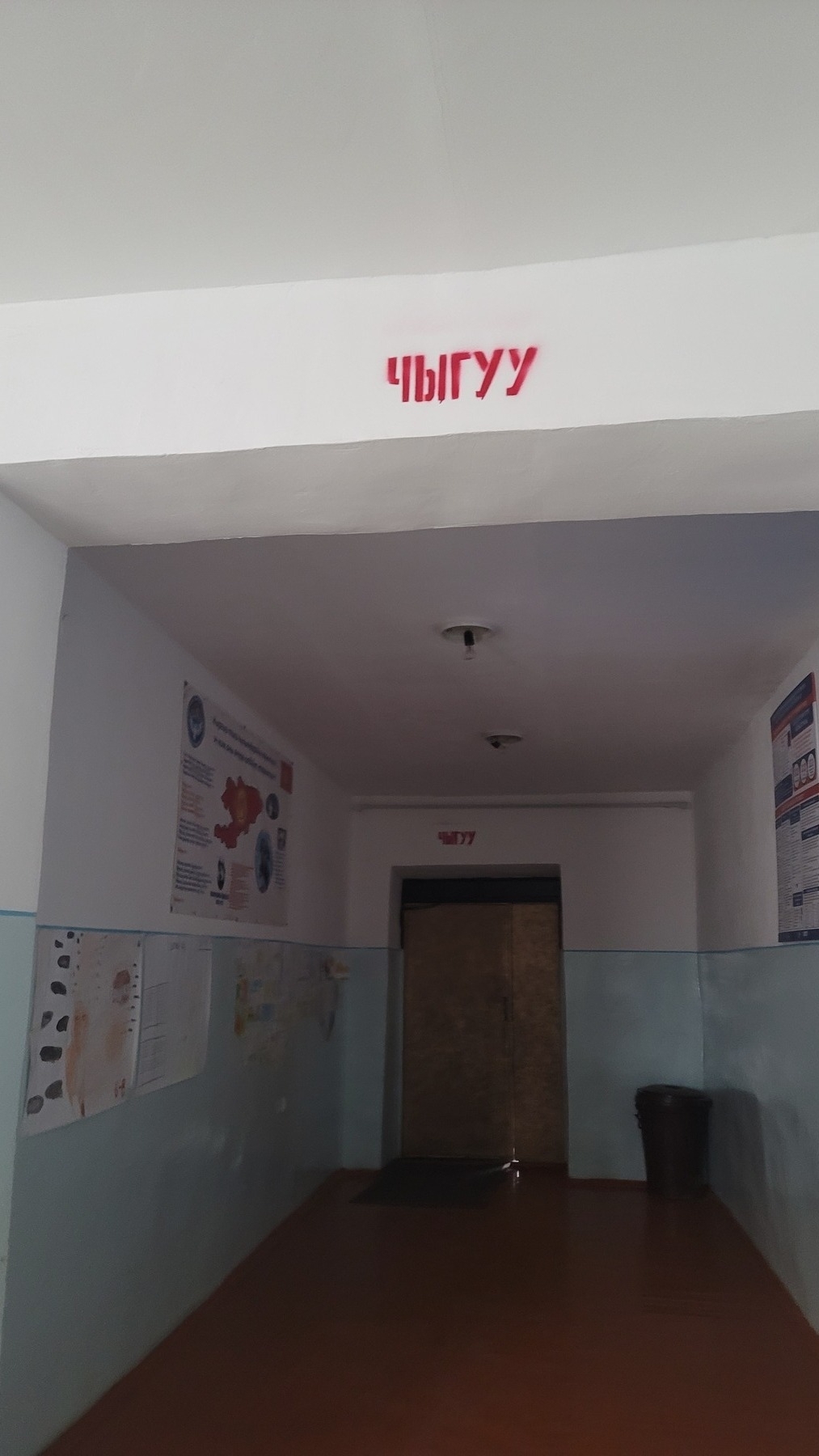 school hall with the Kyrgyz word for exit 'чыгуу' painted in red on a beam