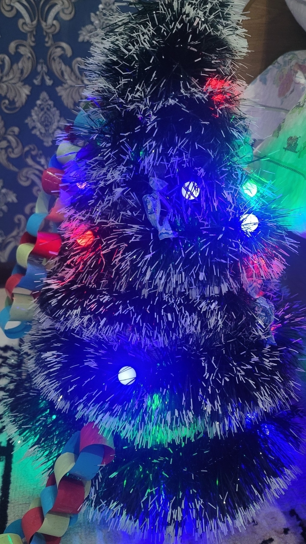 Christmas tree made of a dark garland with white ends and colorful lights wrapped around something