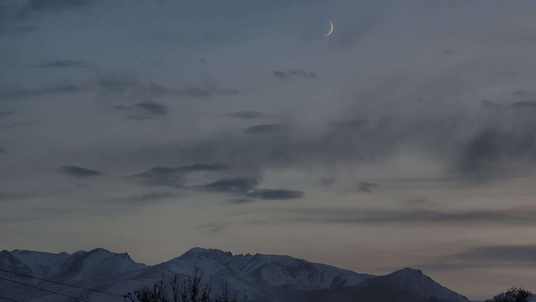 mountains and a crescent moon in the evening