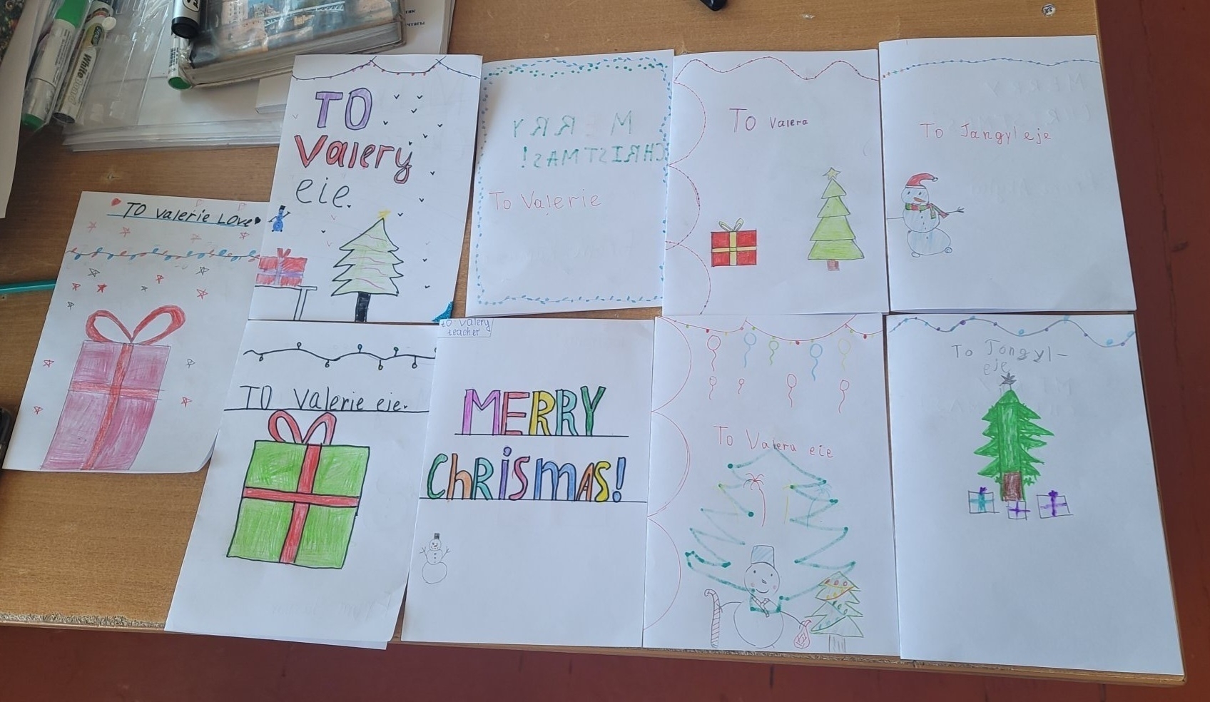 9 hand-drawn Christmas cards on white paper with pictures like gifts, Christmas trees and Christmas lights