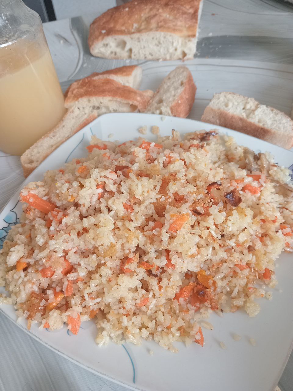 plate of plov (Central Asian fried rice dish with carrots) on a table