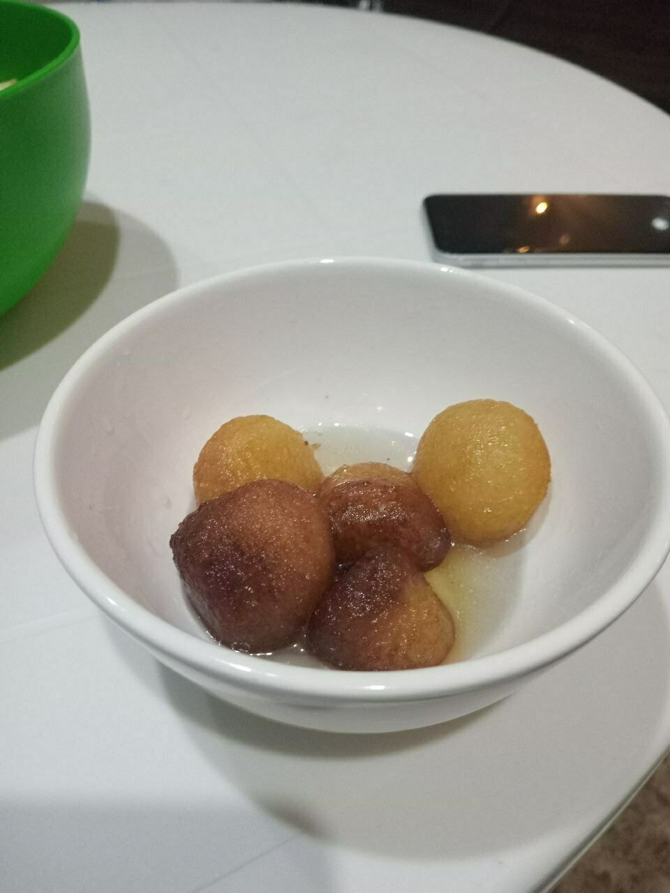 fried balls of dough in a bowl with sugar syrup