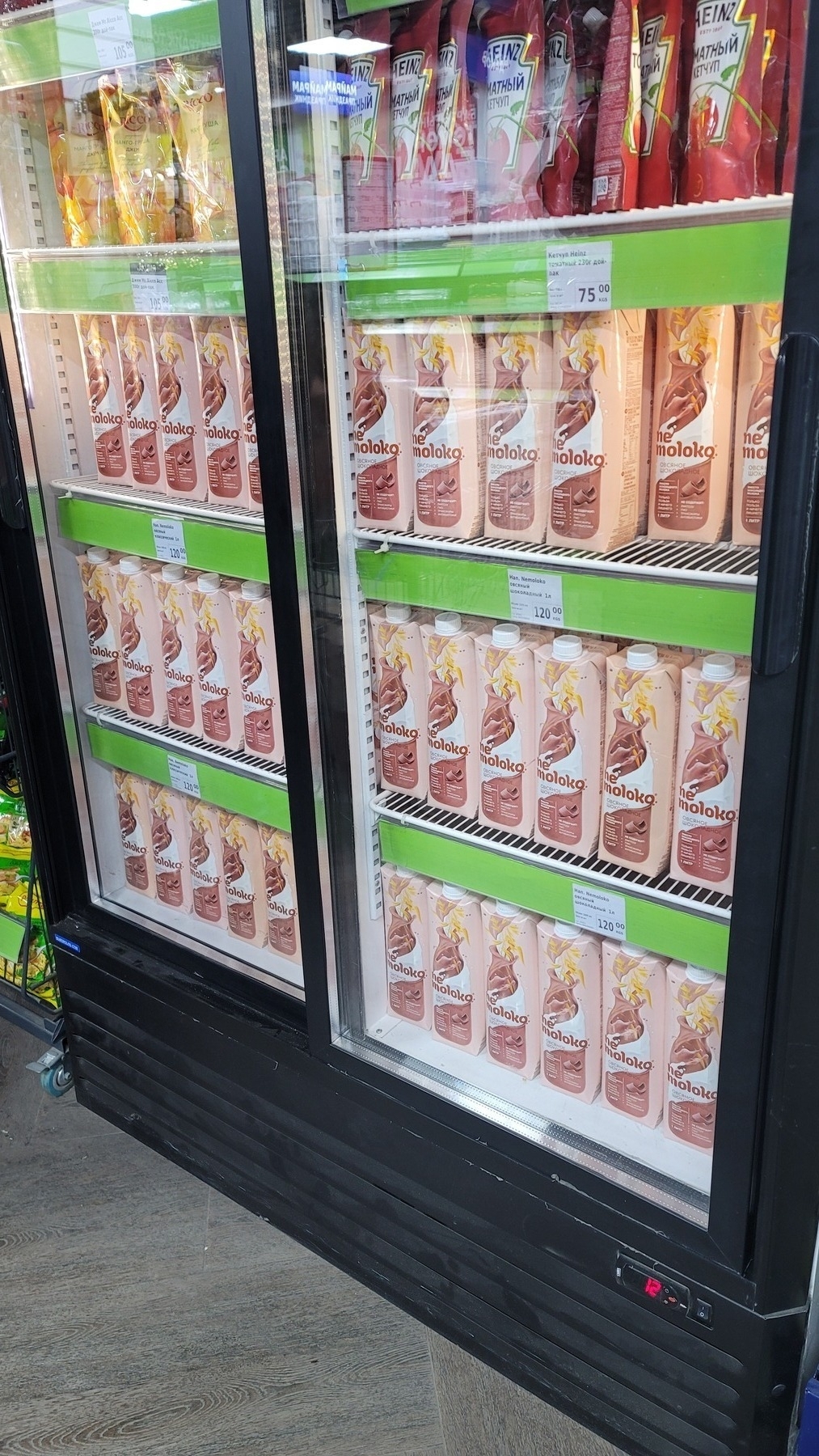 sliding door fridge with 3 shelves (out of 4 in the picture) filled with nemoloko dairy-free chocolate milk