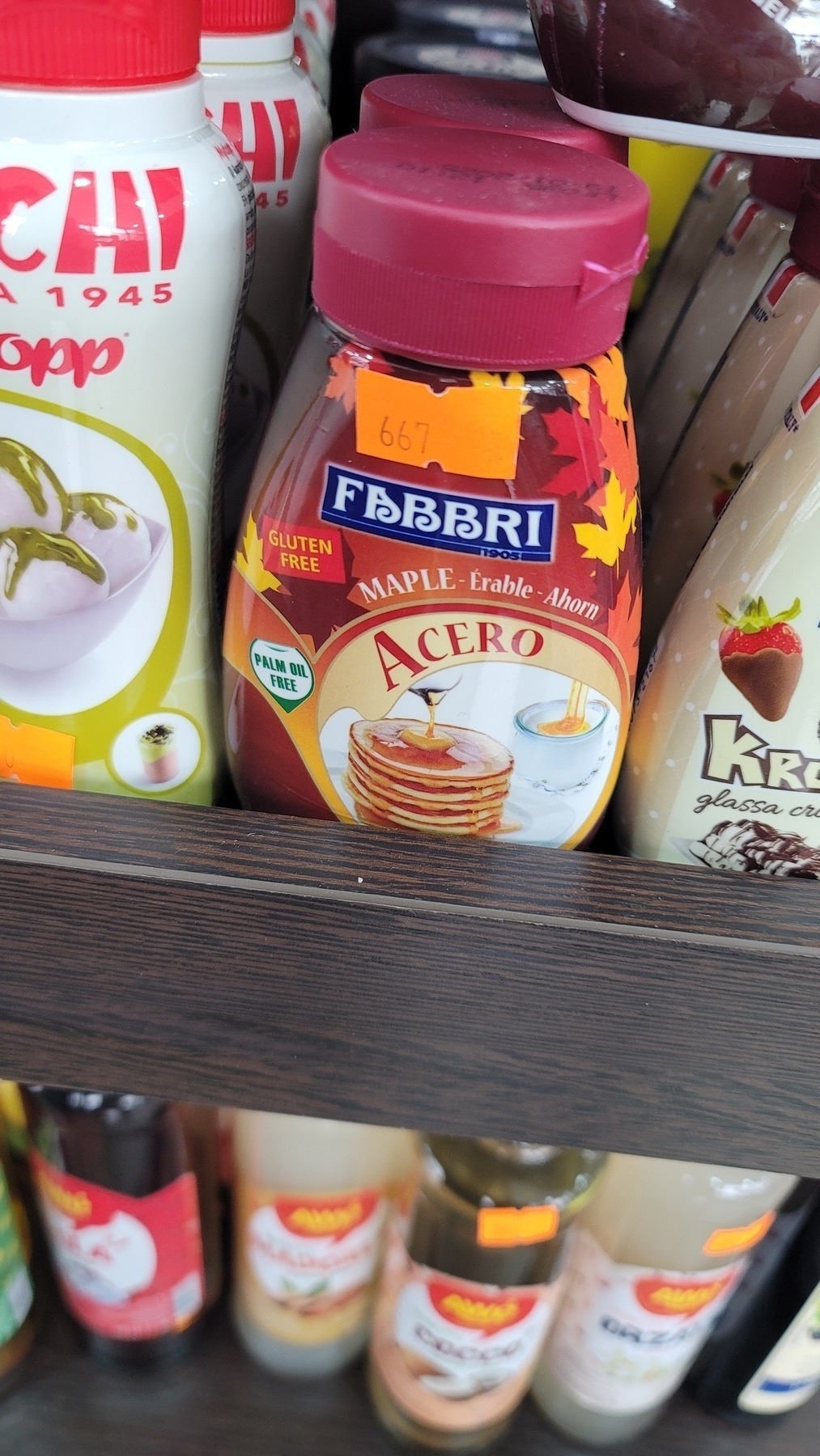Fabbri brand maple syrup bottle on a store shelf, with a 667 som price sticker on it