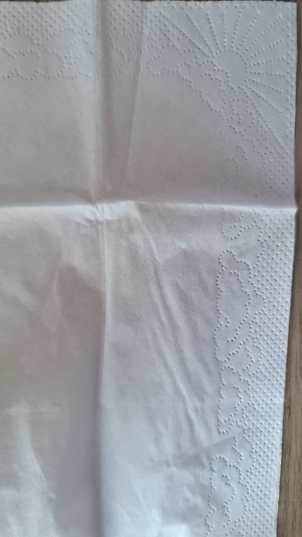 white tissue with a sun made of indented circles in the corner and the same kind of clouds along a border