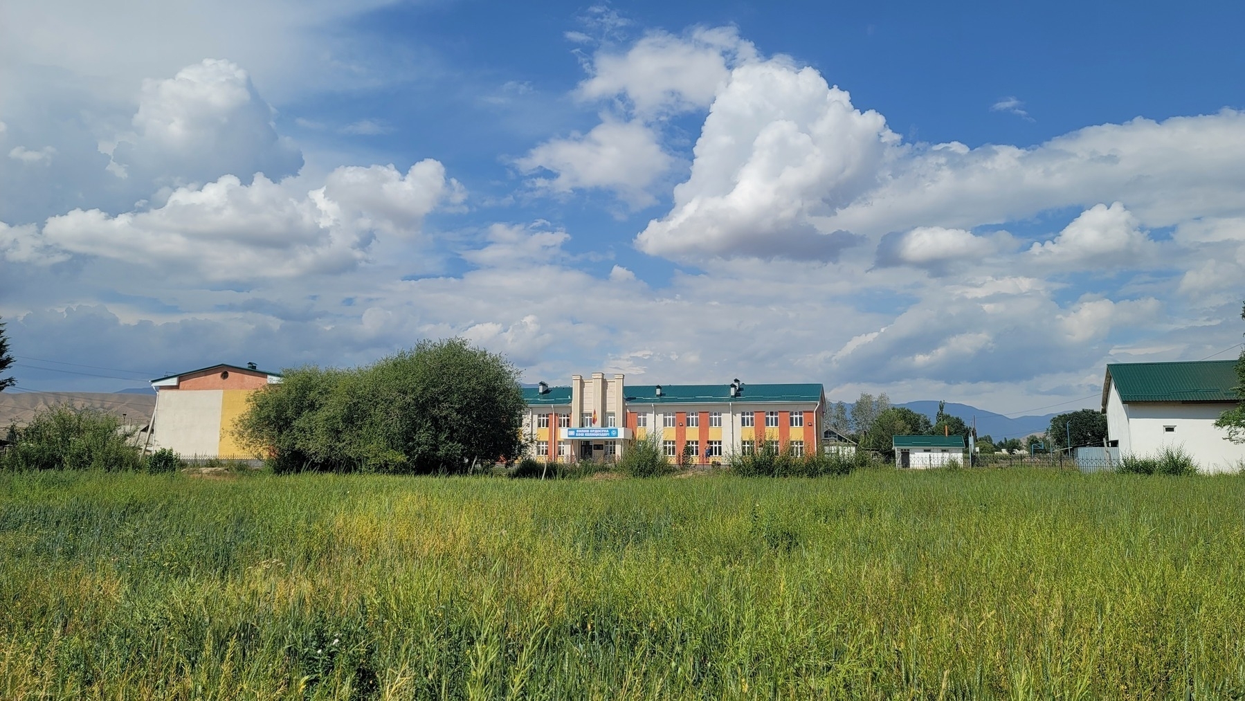 orange, yellow, and white school building with a green roof