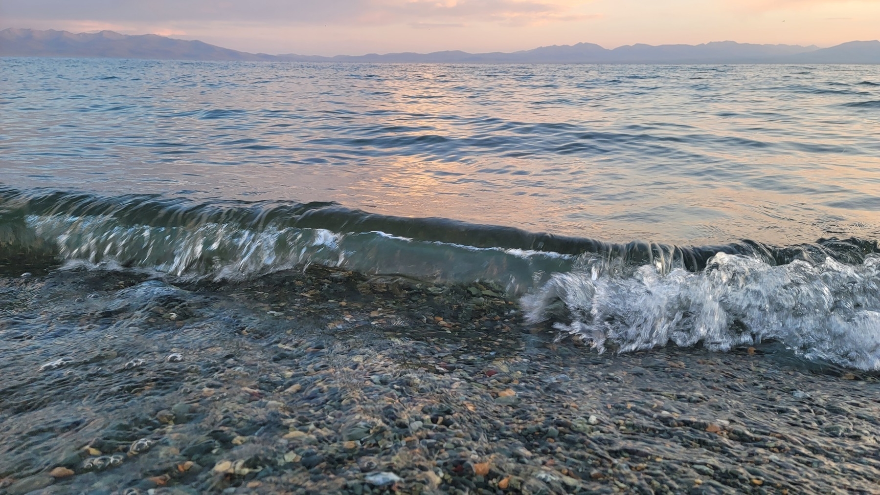 wave on a lake, mountains in the background