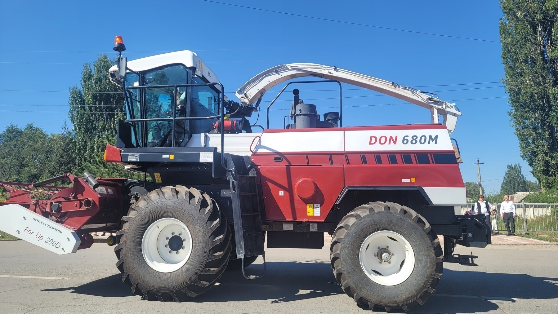 new looking red and white tractor type vehicle with a fire extinguisher strapped outside near the driver's seat