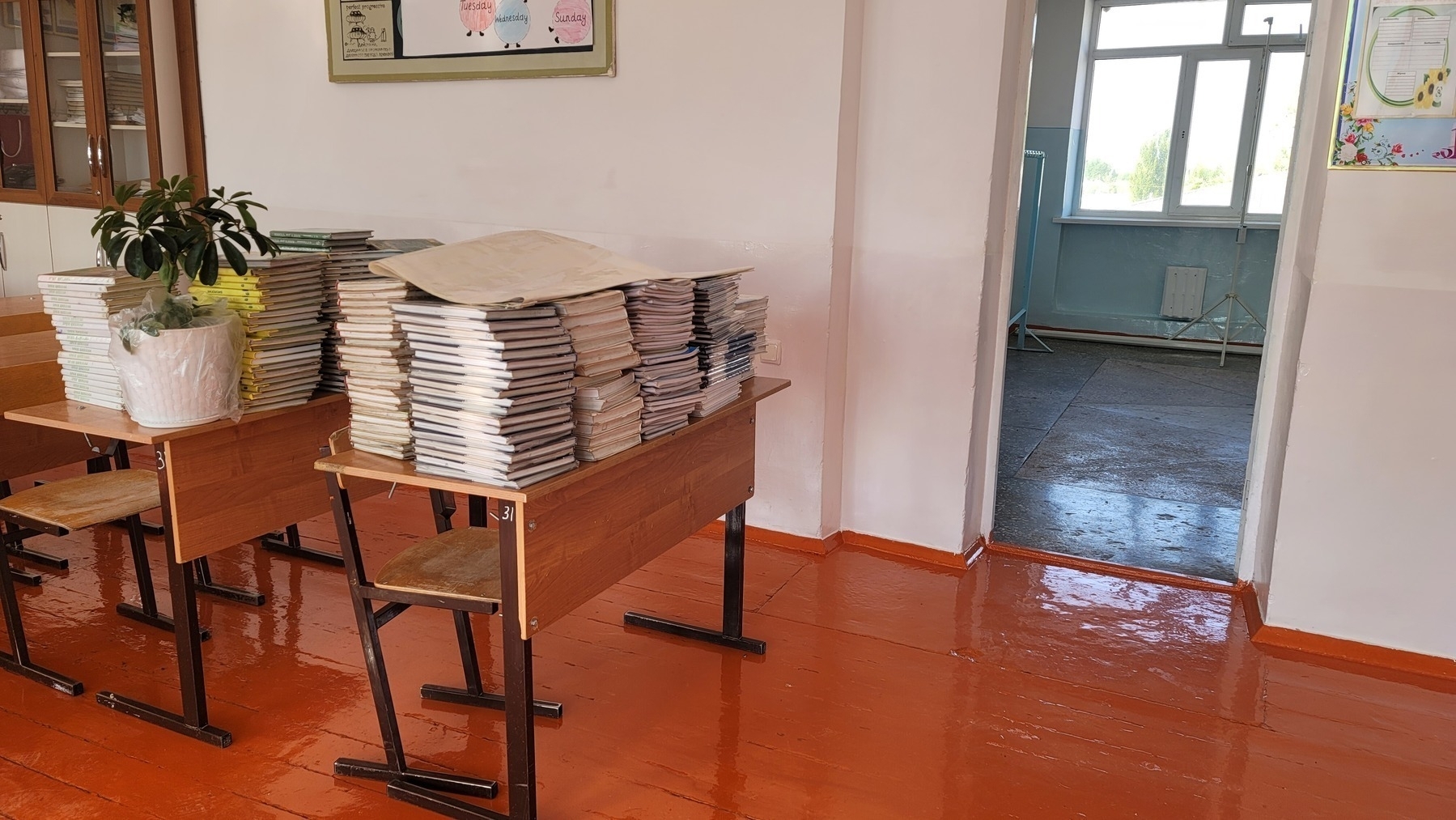 two school desks with stacks of textbooks on them