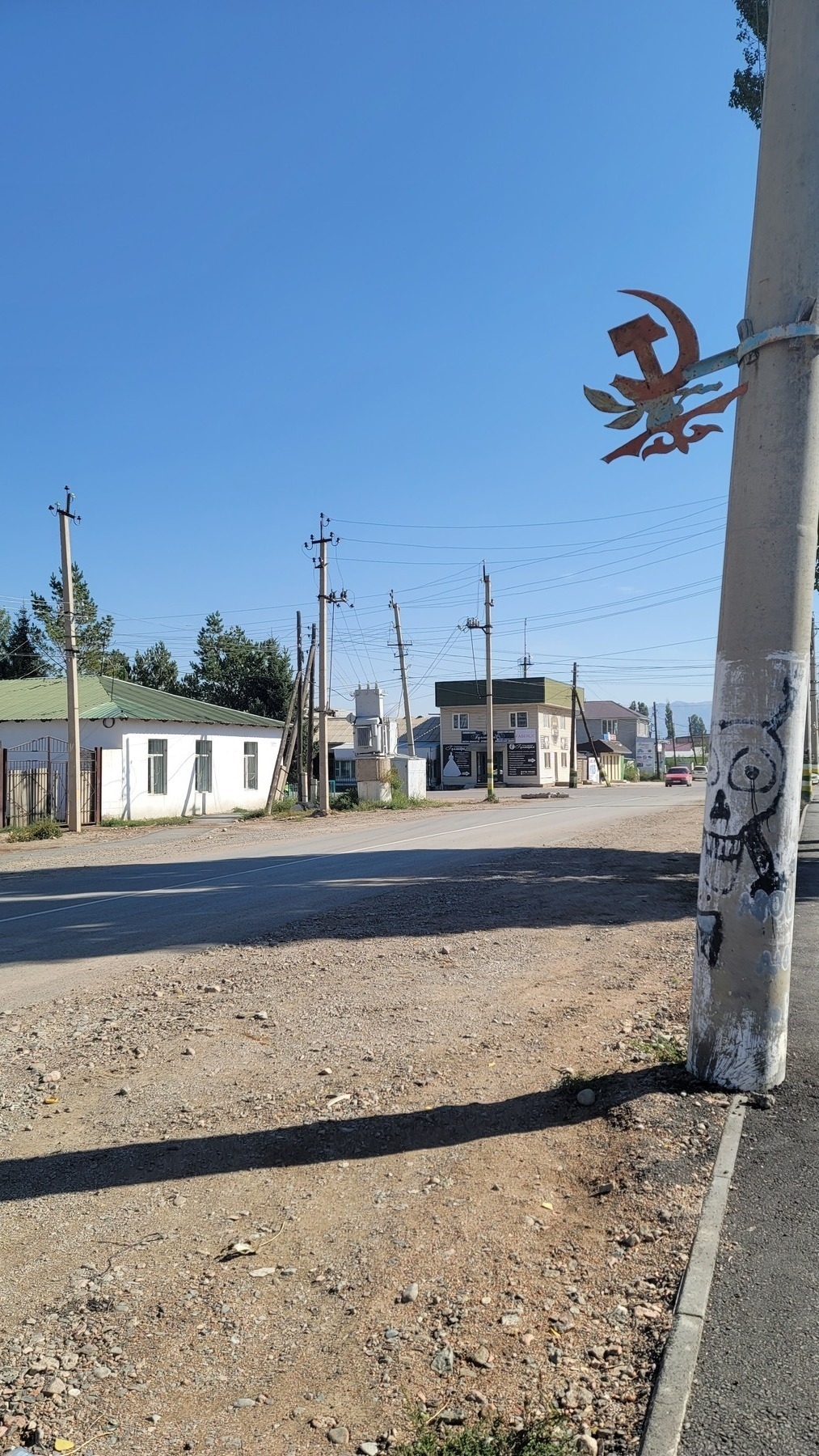 metal 'hammer and sickle' decoration on a metal band fixed around a traffic pole 