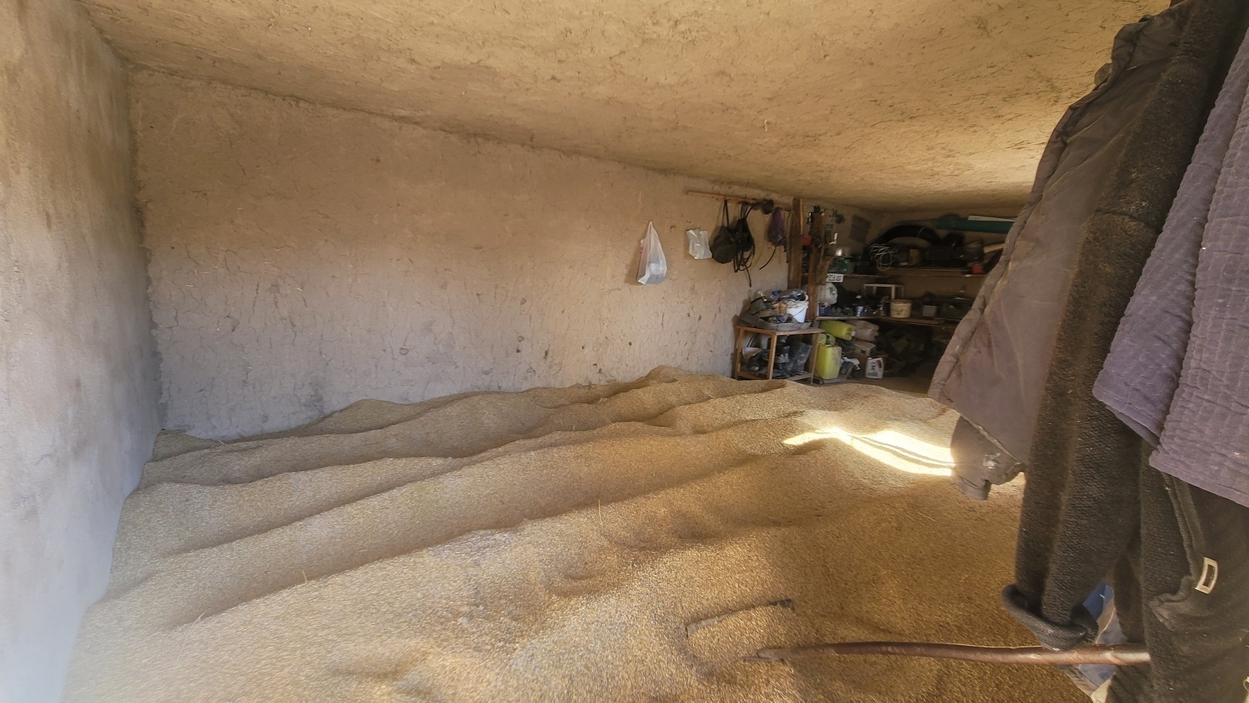 grain dunes completely covering the floor of an outdoor storage room