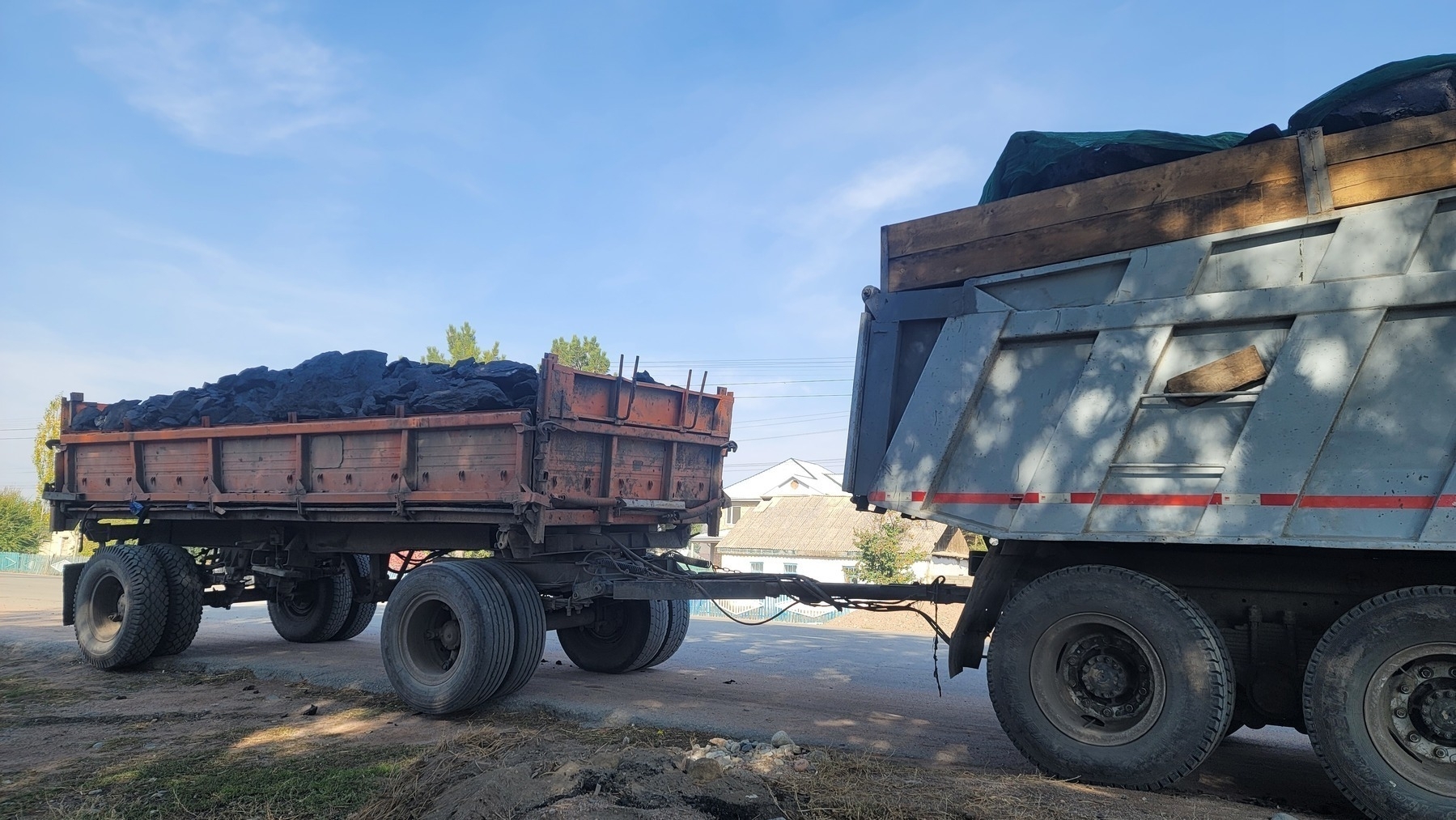 vehicle with a trailer hooked up to it, both containing coal