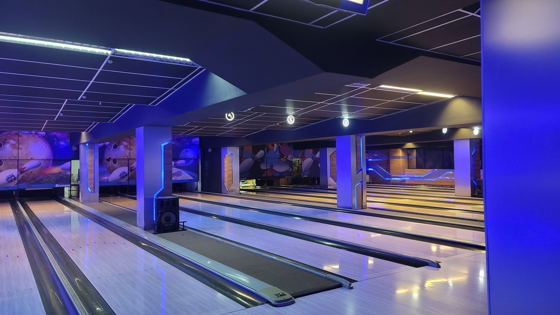 dark and empty bowling room with cool-colored blue and purple lights