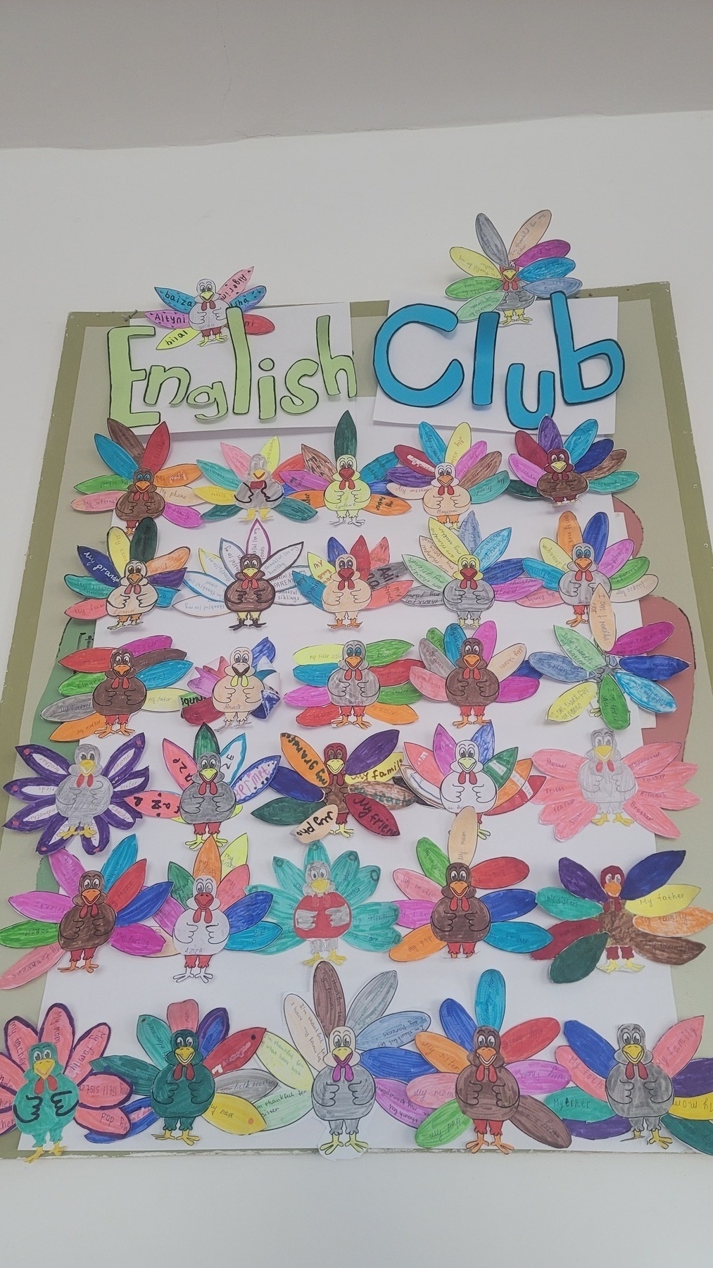 colorful paper turkeys on a board on a wall in a classroom 