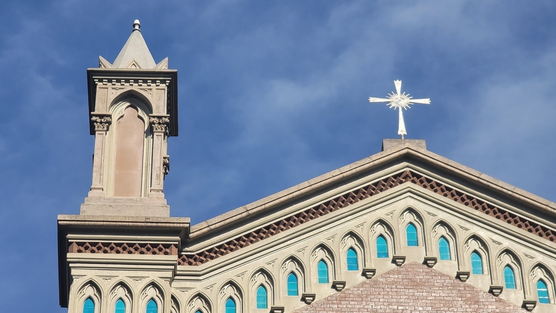 top of a light colored church with light blue windows 