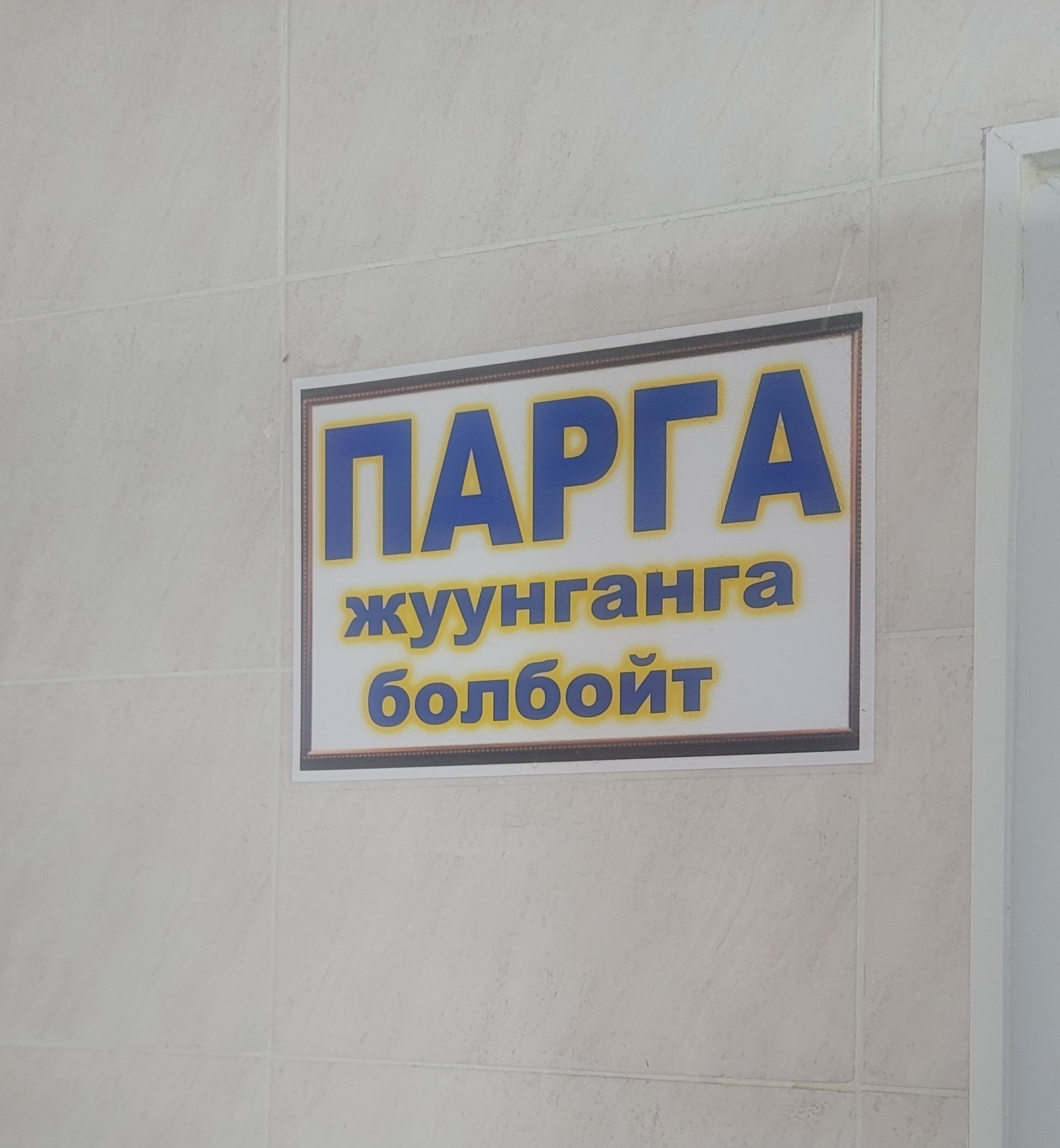 sign on a wall which seems to be mostly in Kyrgyz with the following text: парга жуунганга болбойт