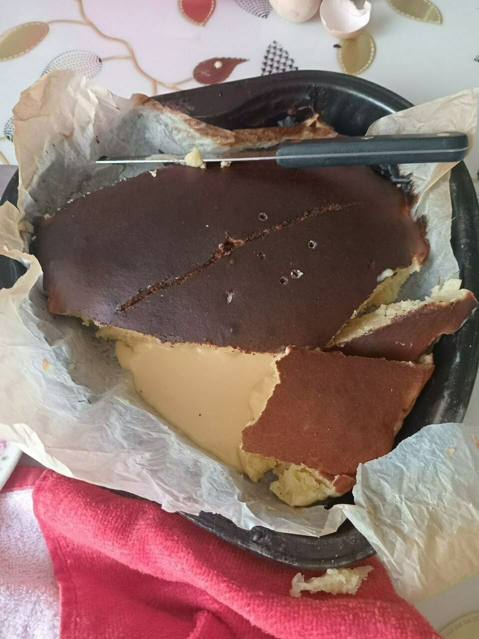pastry in a heart shaped baking pan with a brown top but cut open to reveal pale, uncooked batter inside