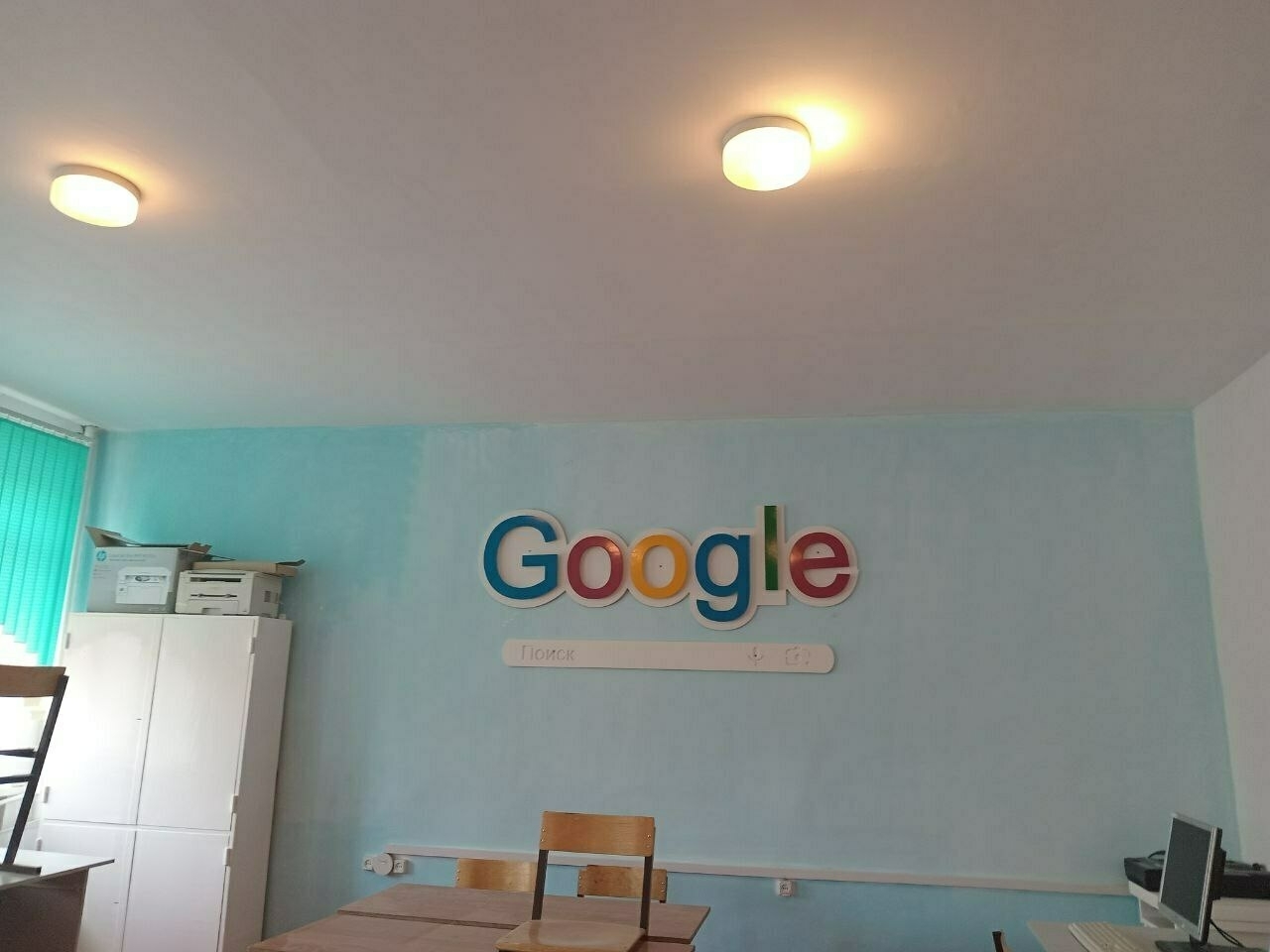 in a computer lab with a "Google" logo and search bar wall decoration
