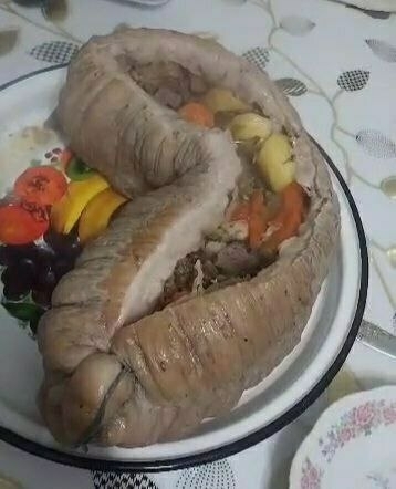 some kind of thick-looking intestine thing which is on a plate cut open with meat and vegetables inside