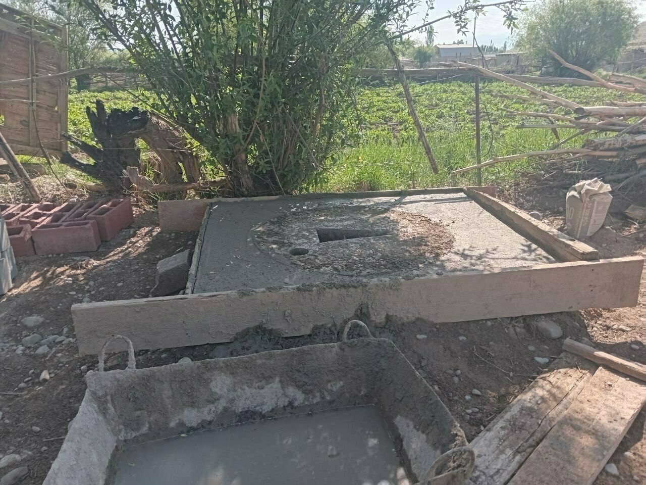 base/foundation of an outdoor toilet made of concrete with a hole cut in it already