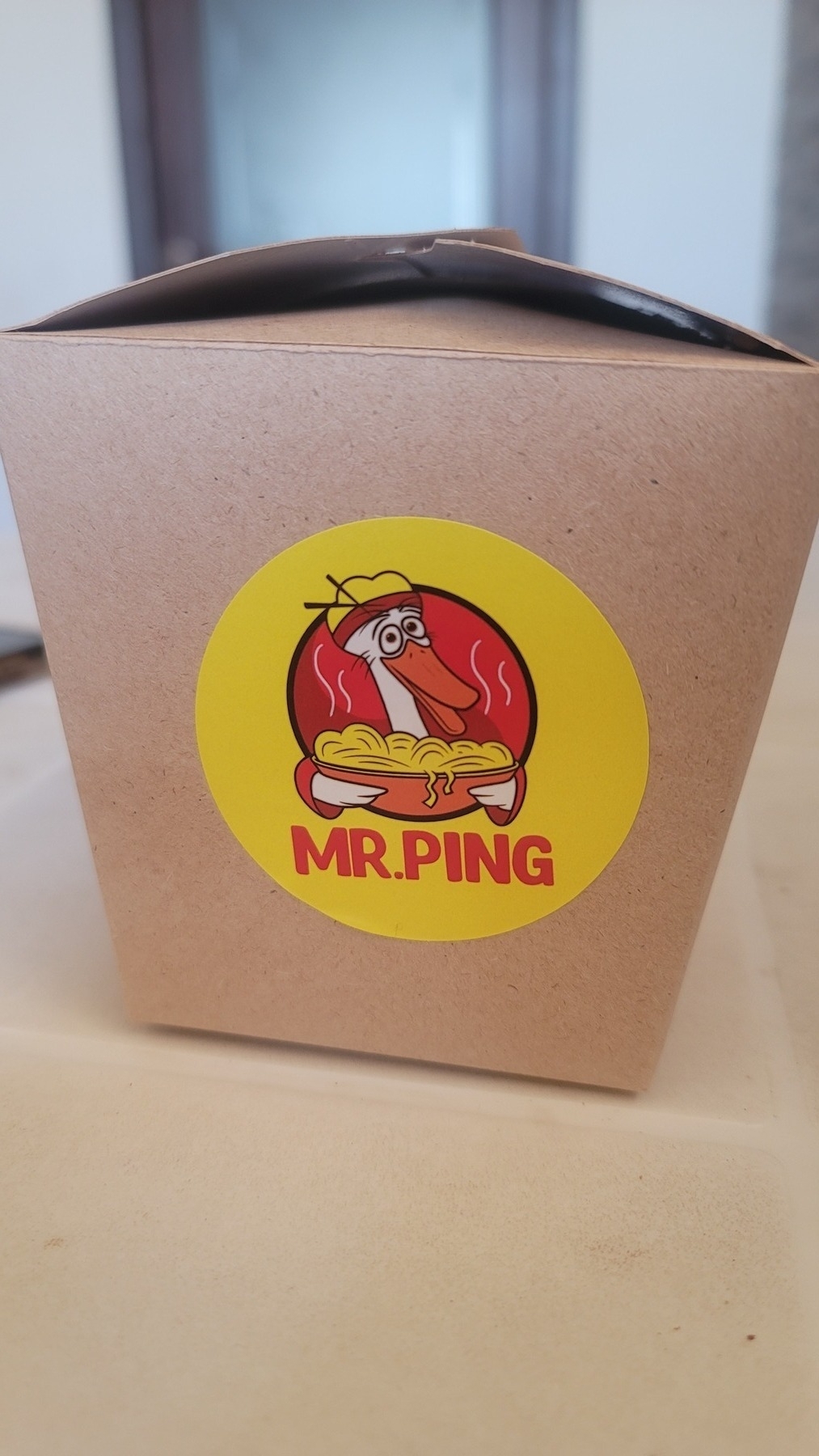 brown rice carton with a sticker labeled "Mr. Ping" and a picture of a crane (Po's dad) from Kung Fu Panda