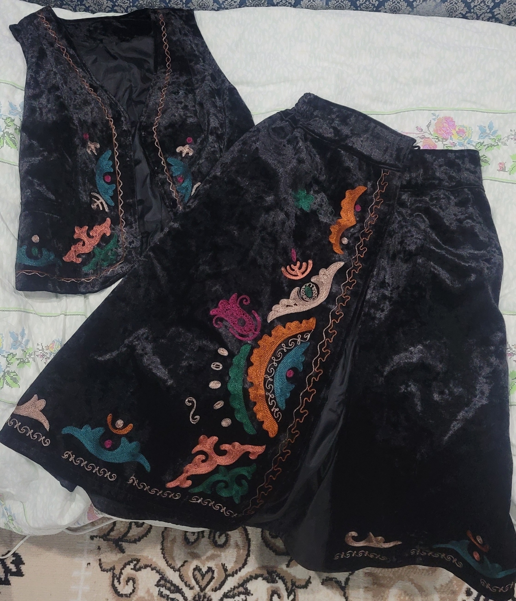 black vest and skirt with colorful, embroidered patterns