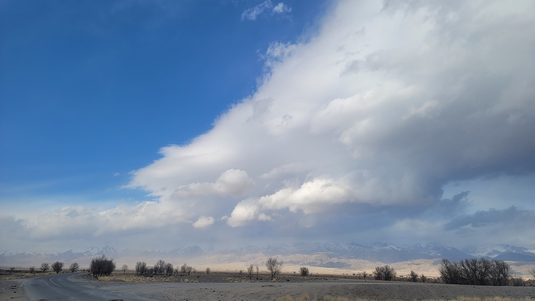 road going towards mountains. clouds in the sky