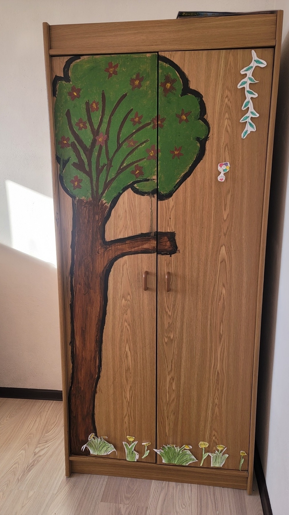 wardrobe with a cartoon-ish looking tree painted on it