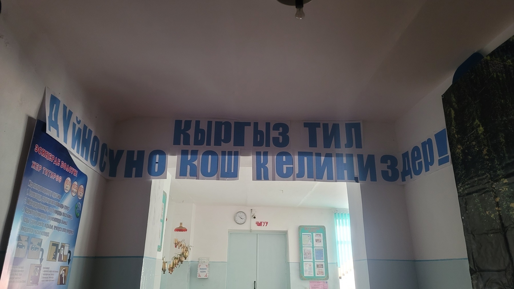 typed Cyrillic letters printed out and taped to the arch of a hall in the main school entrance