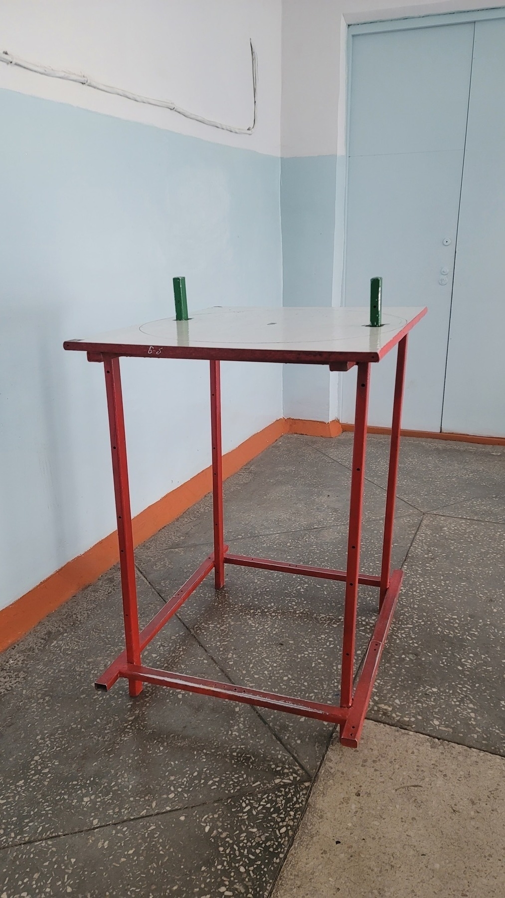 a tall table with two short, green poles jutting out of the top