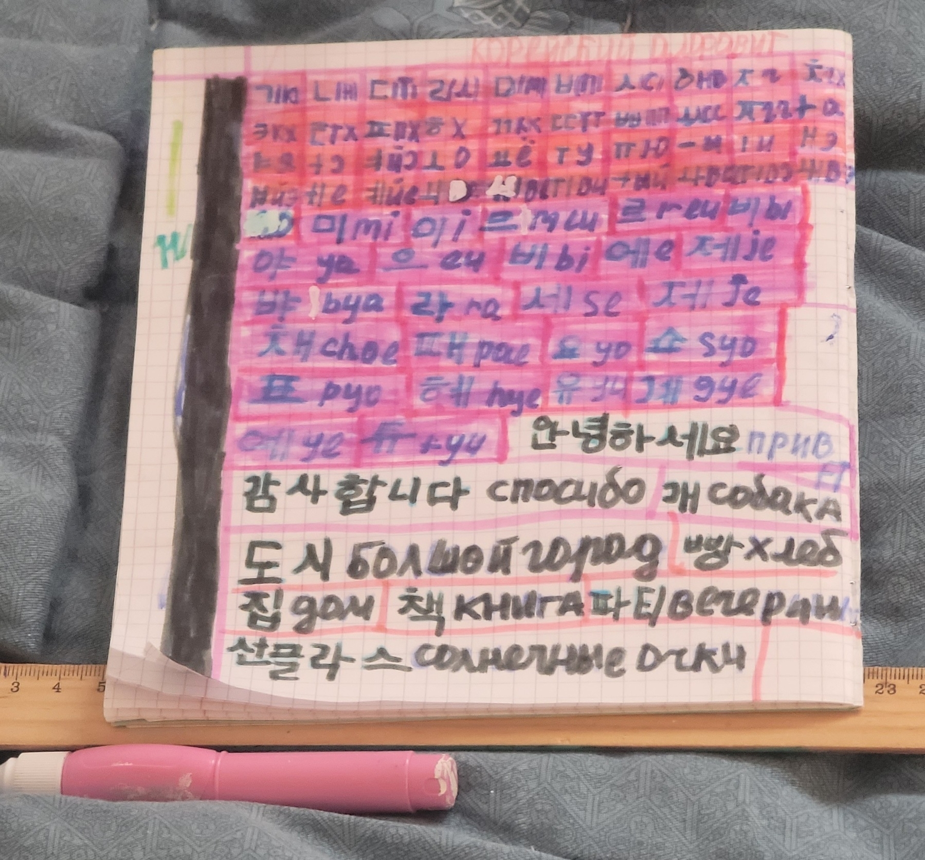 Korean letters and phrases written and transcribed and or translated into Russian on a notebook page in colorful marker