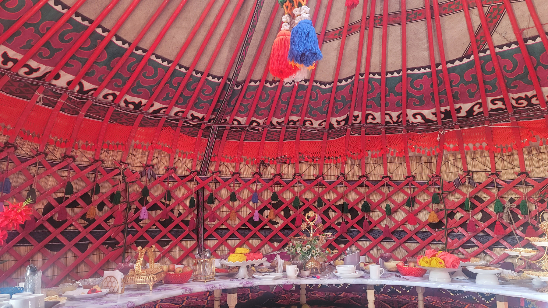 inside a yurt with a long curved table set up for guests to eat at