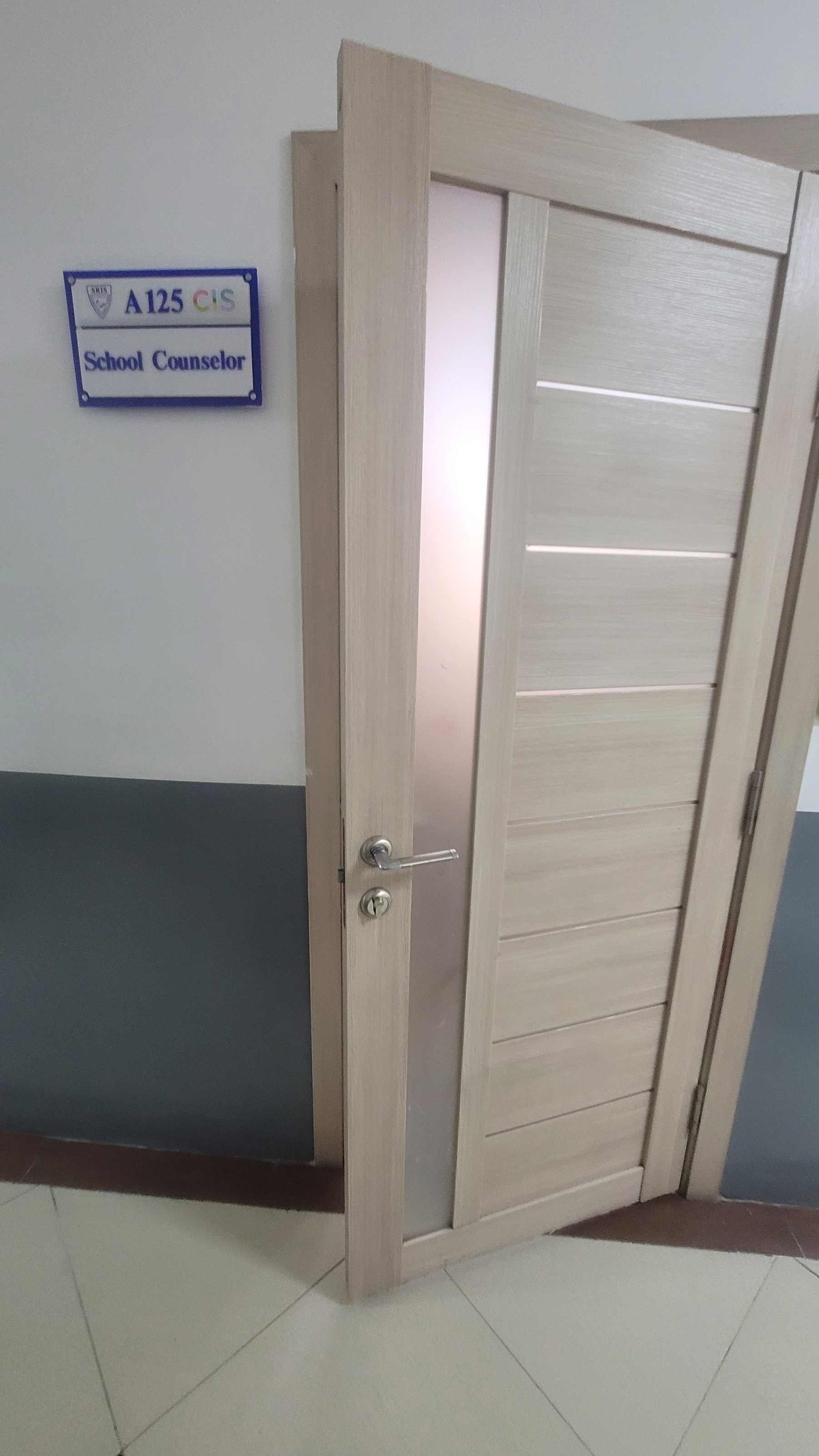 Slightly ajar door with a sign on the left reading 'School Counselor'