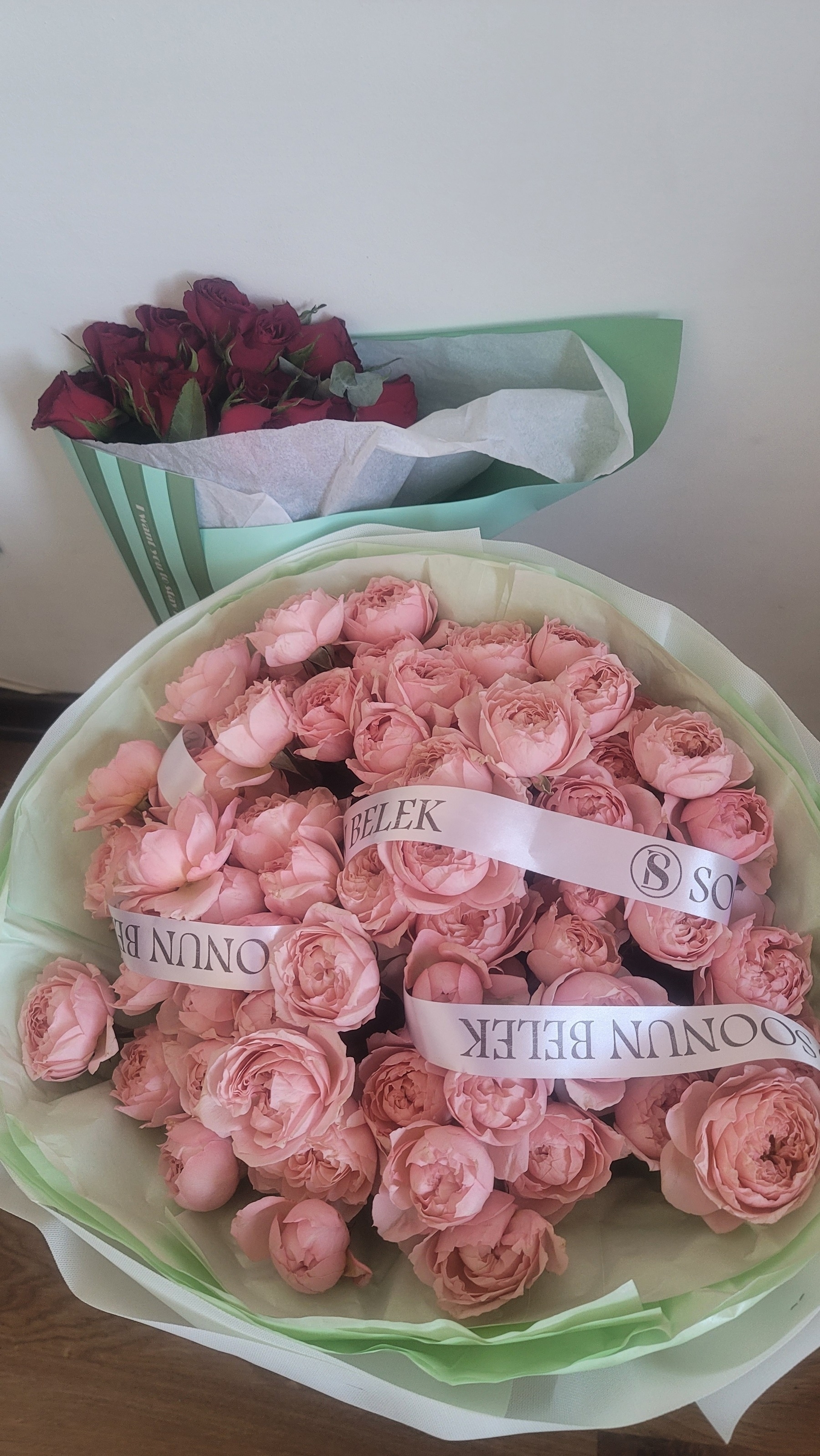 large bouquet of light pink roses, and a smaller bouquet of red roses