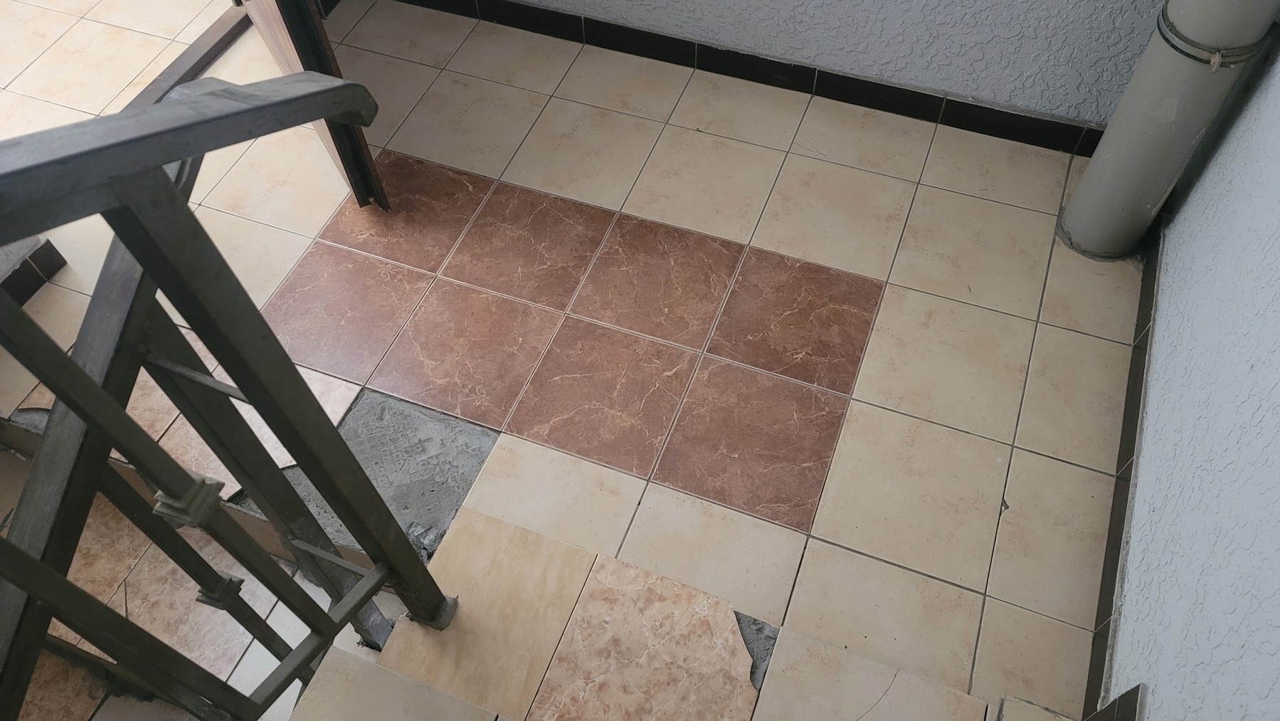 tiled floor and stairs with some missing parts of tiles and some chipped tiles