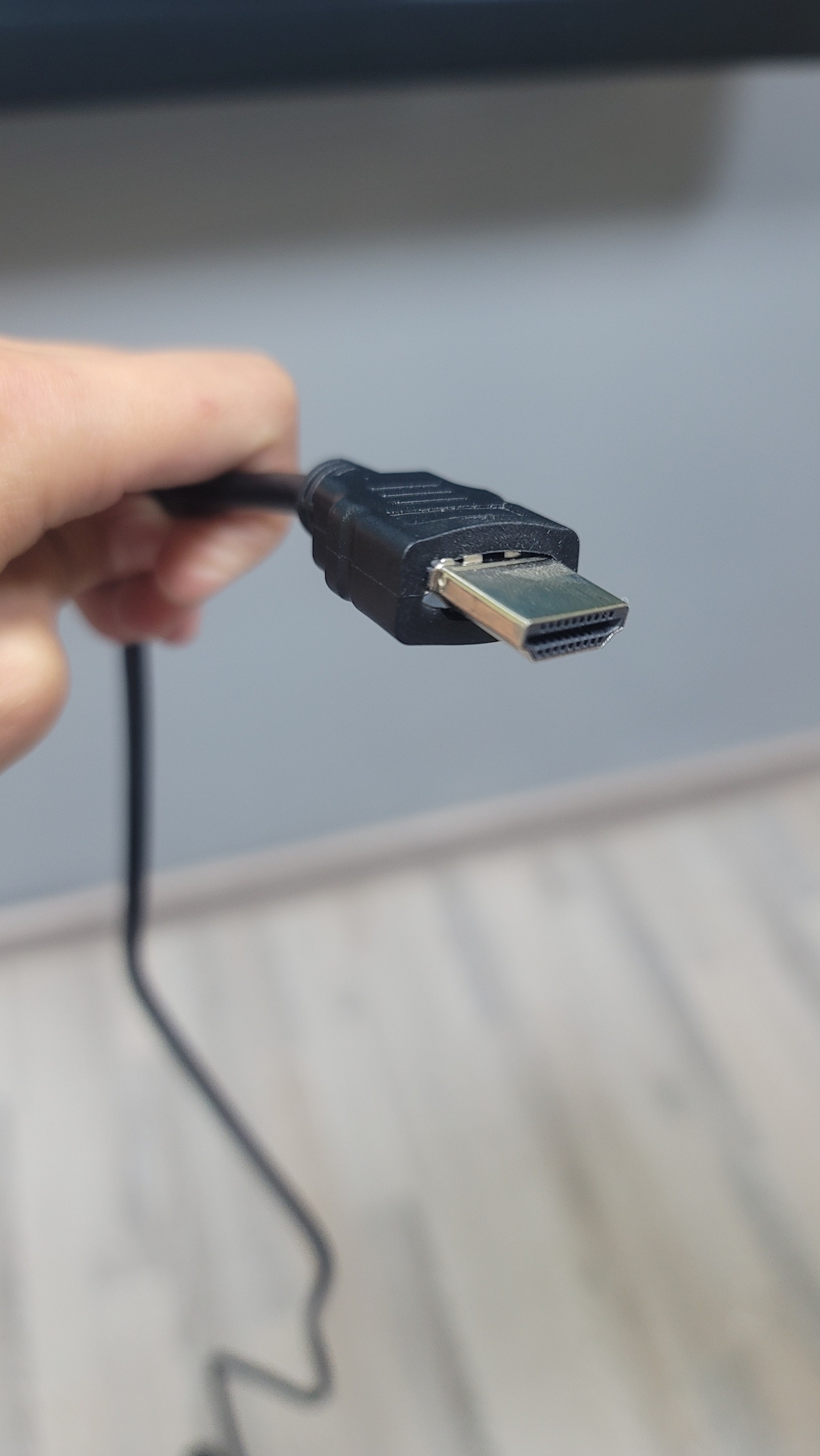One end of a black HDMI cable with the metal part bent slightly downwards