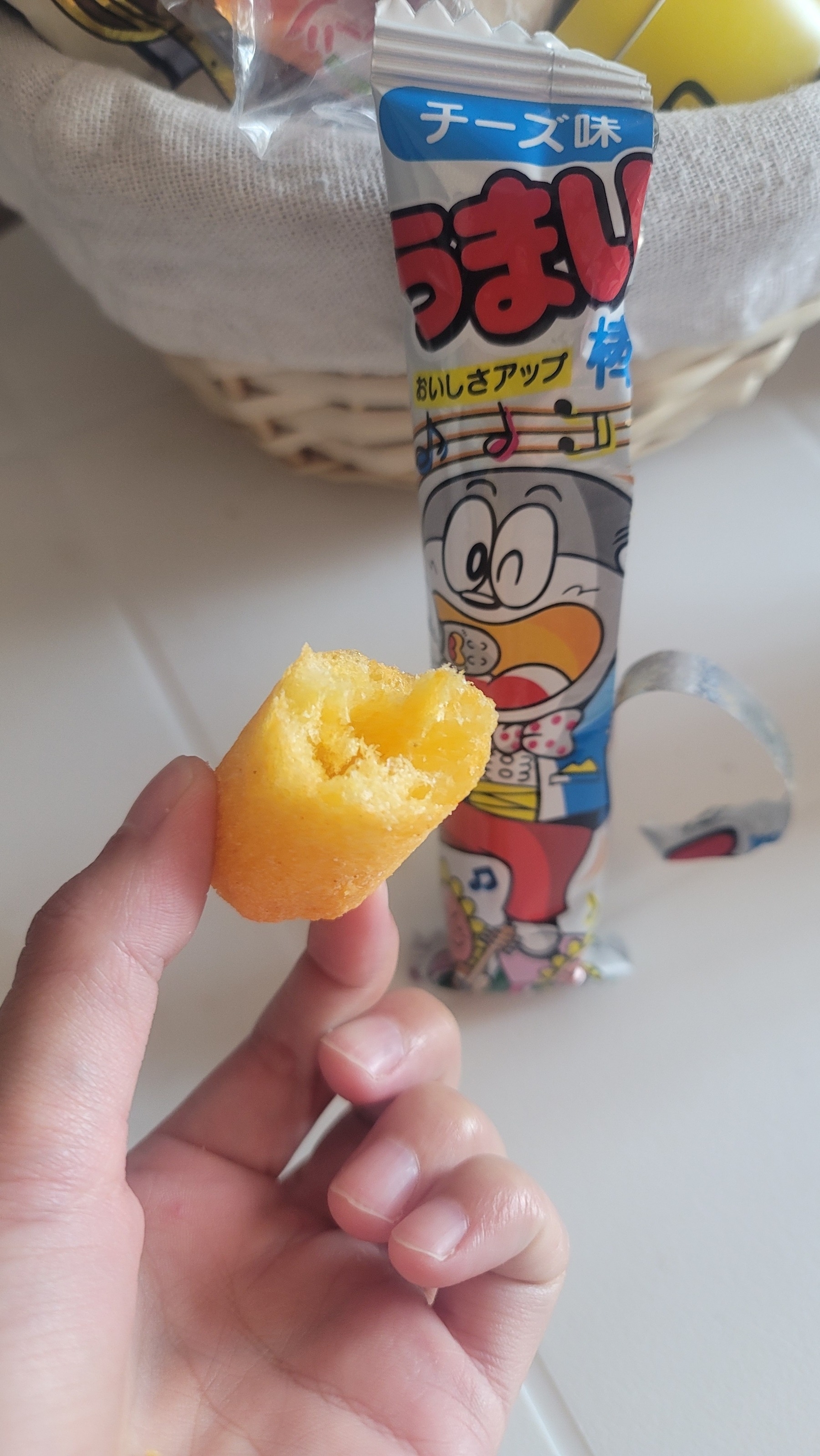 Part of a snack that looks like a giant cheeto with a hole in the middle, next to the snack wrapper