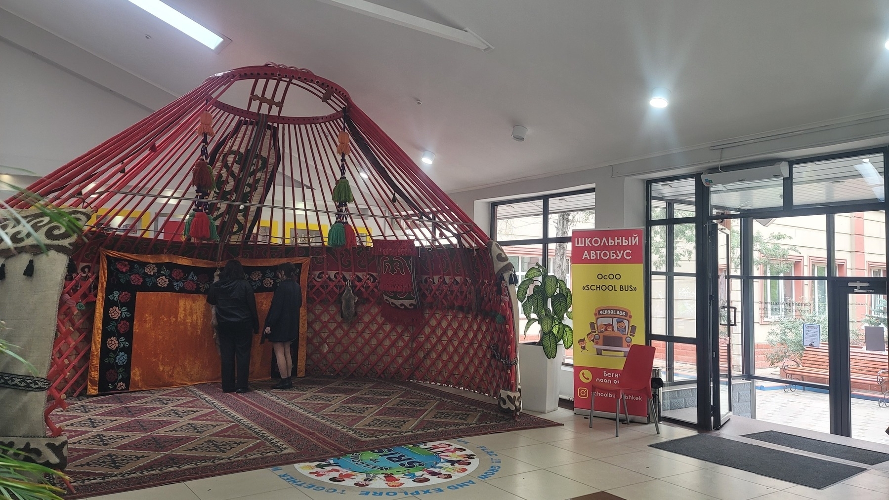 half of a yurt set up inside the lobby of a school 