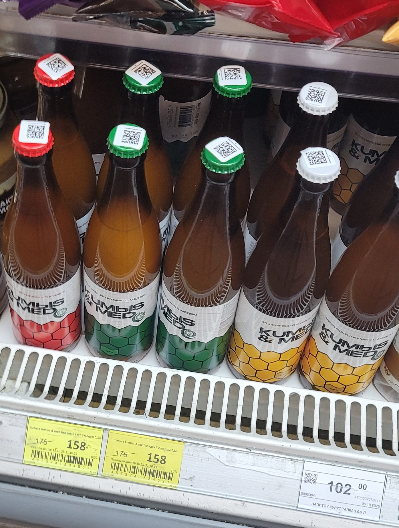 bottles of kumis and honey on a refrigerated shelf in a store