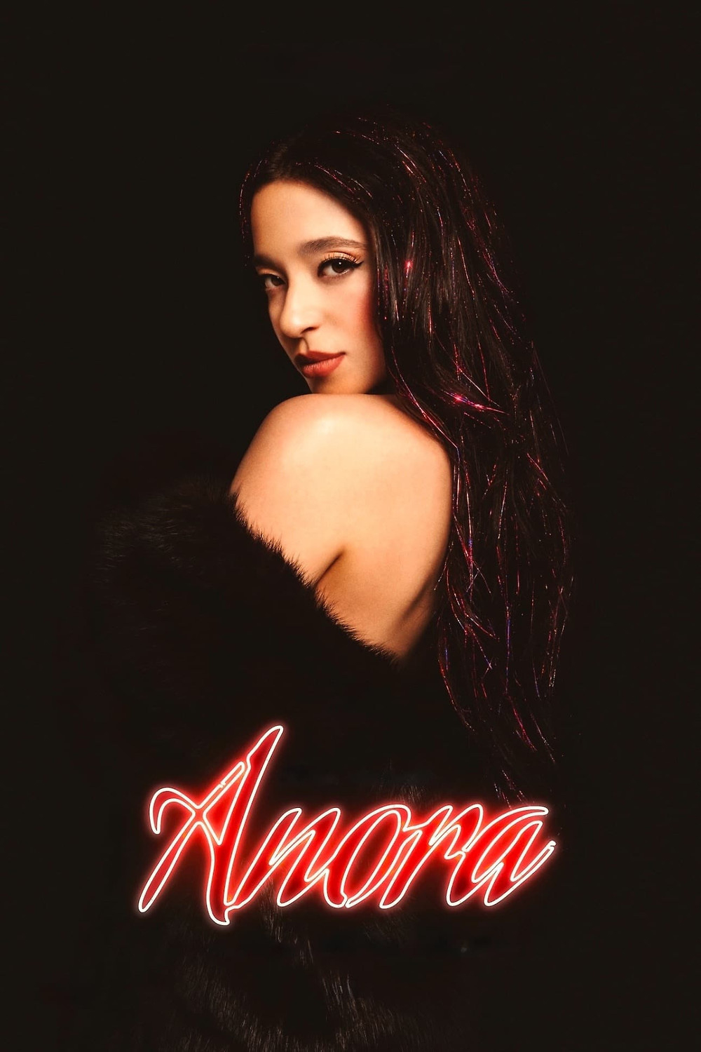 A woman with long dark hair and dramatic makeup poses against a dark background, with "Anora" written in glowing red script.