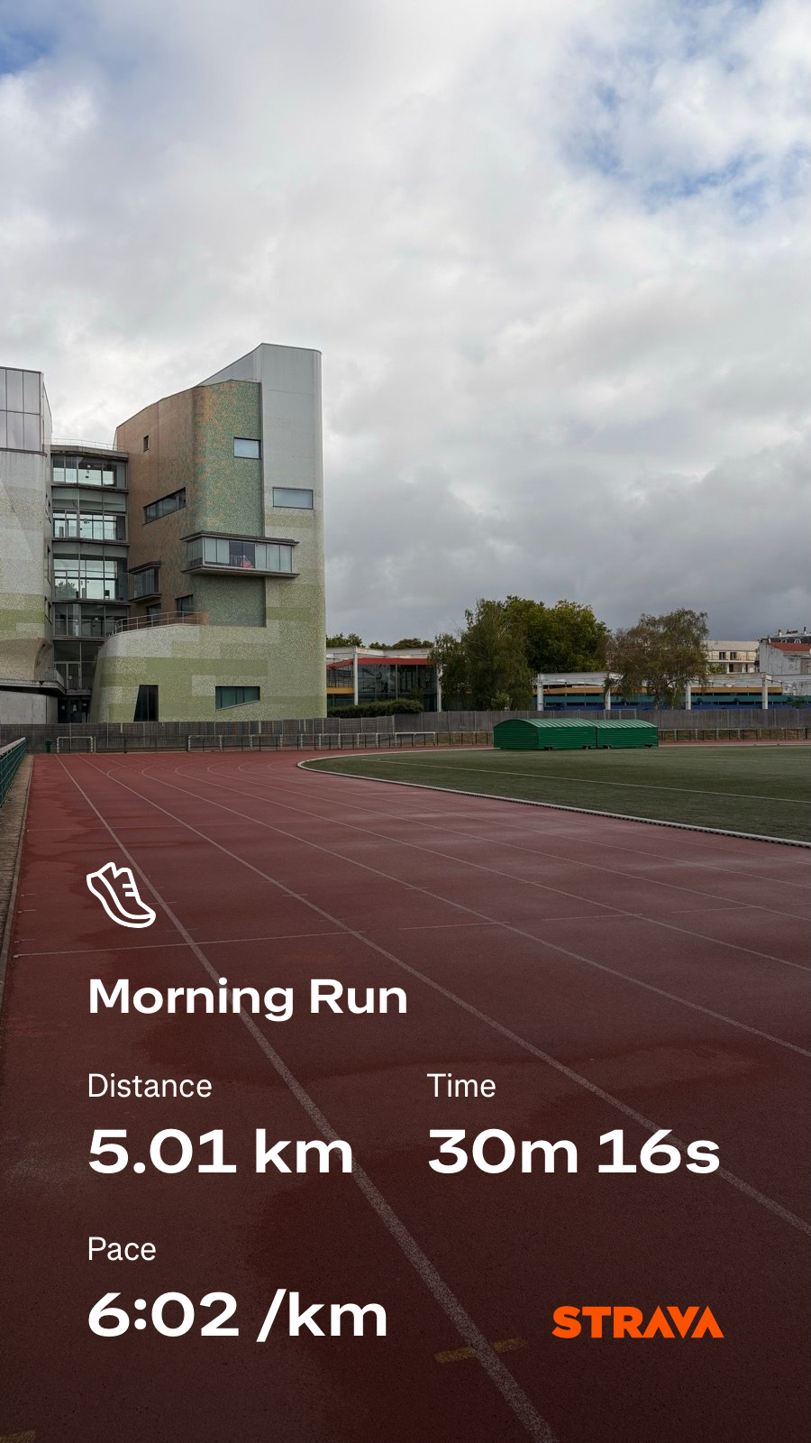 A running track leads past a modern building under a cloudy sky, accompanied by Strava workout statistics for a morning run.