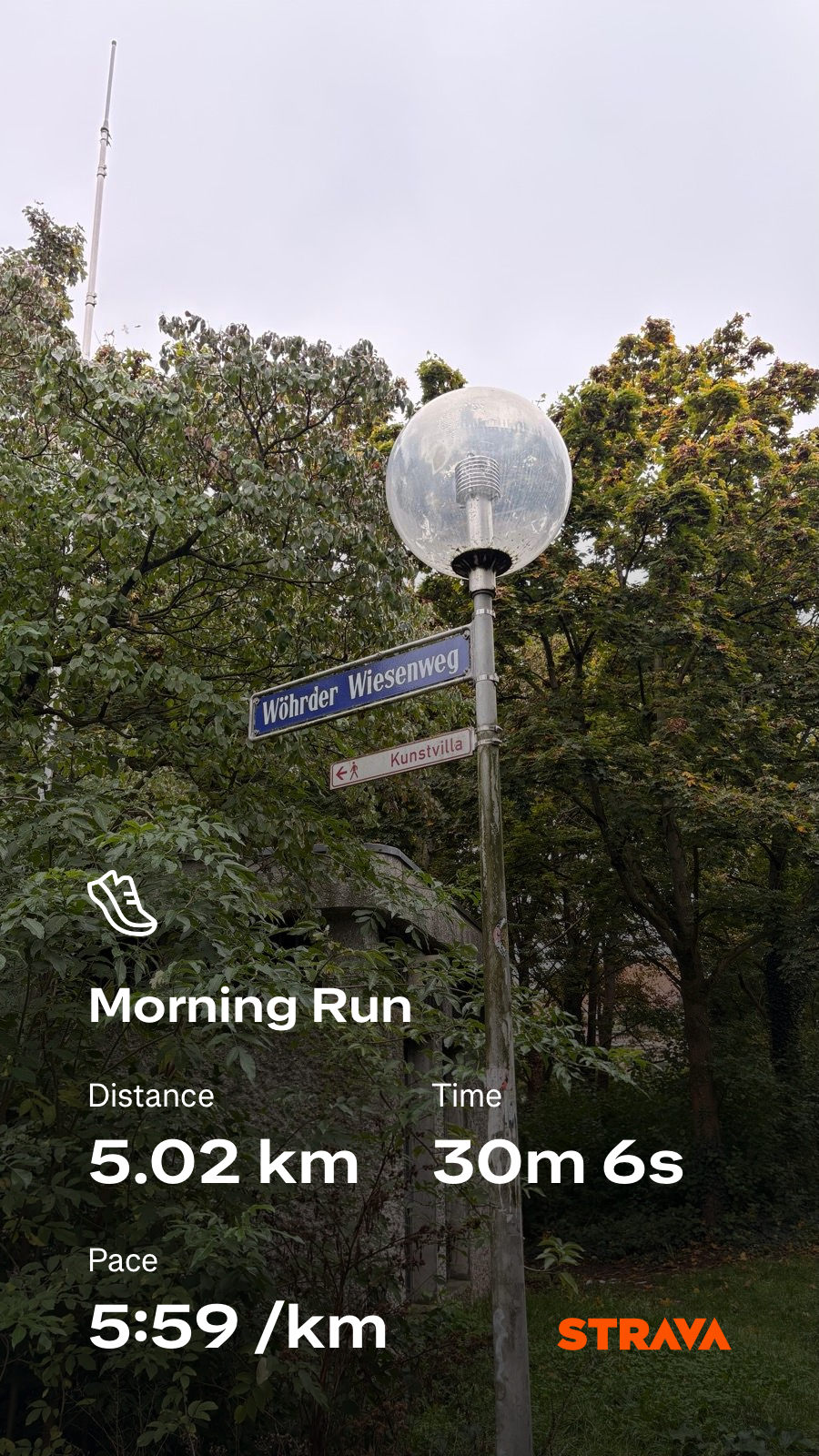 A signpost partially obscured by trees stands beside a street lamp, with running statistics for a 5.02 km morning run displayed at the bottom.