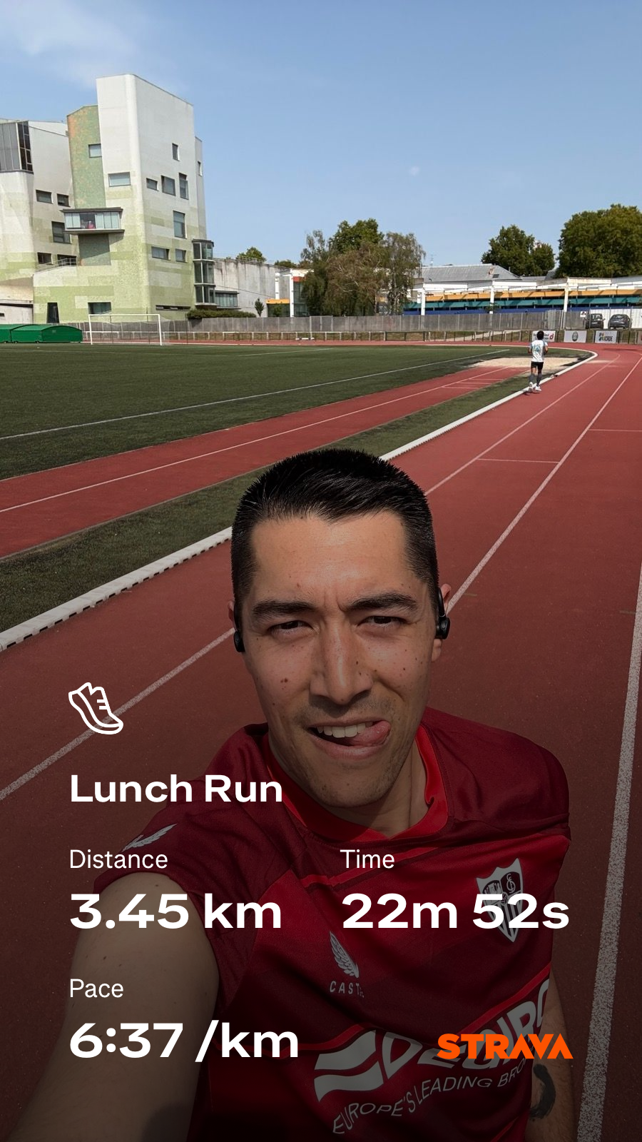 A person wearing a red shirt is taking a selfie on an outdoor running track, with workout details overlaid on the image.