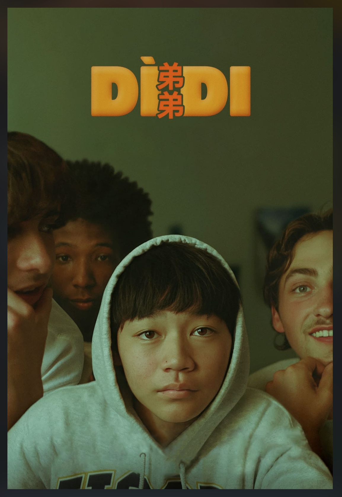 A group of four young people are looking towards the camera, with one person in the center wearing a hoodie.