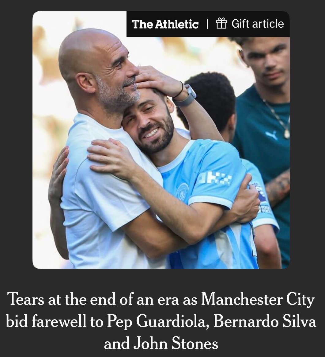 Two men are hugging each other, surrounded by other people, and wearing football attire.