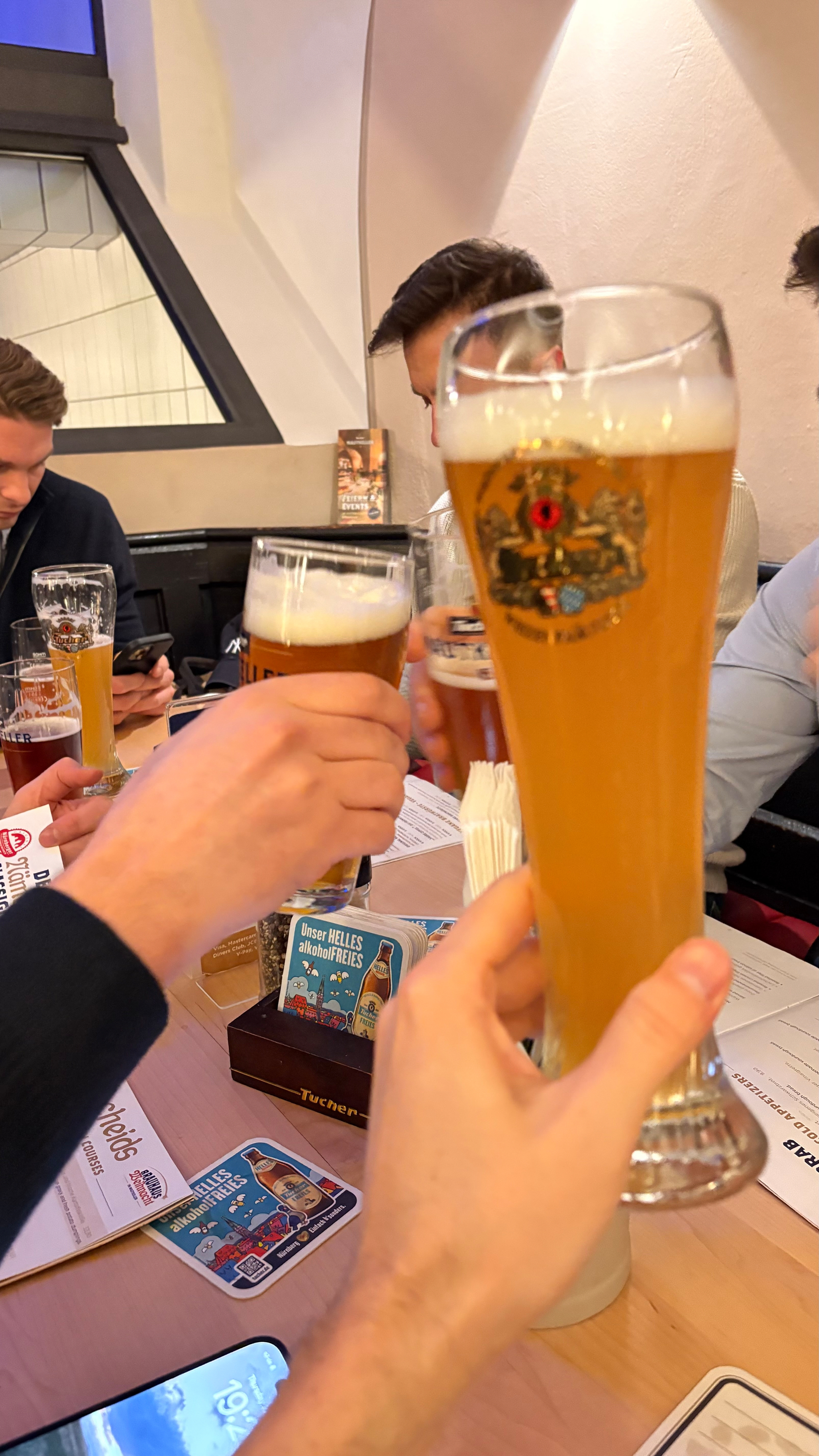 A group of people are clinking glasses filled with beer in a casual setting.