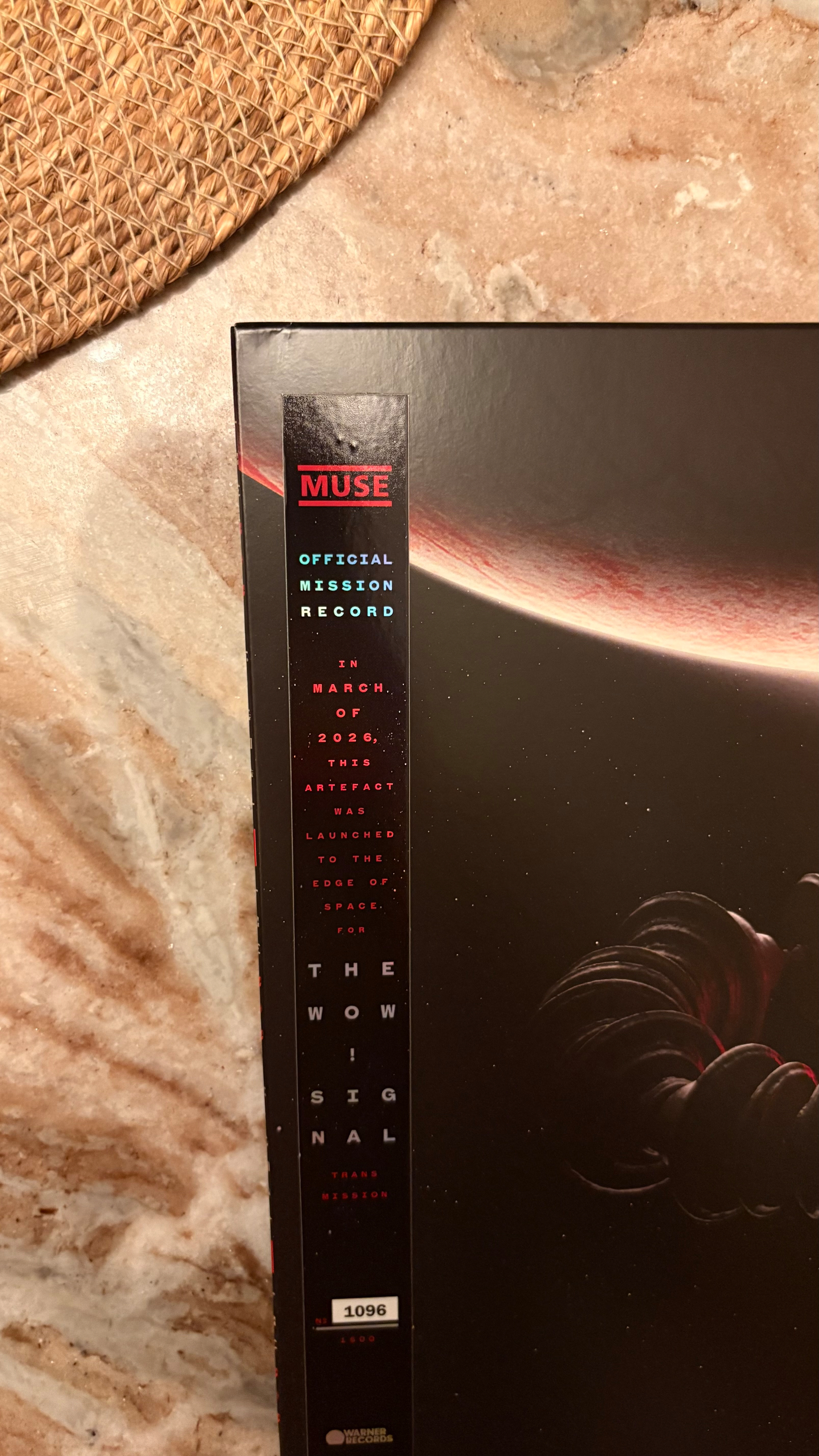 The corner of a Muse album cover titled The Wow Signal is shown, mentioning its launch to the edge of space in March 2026 as an official mission record.