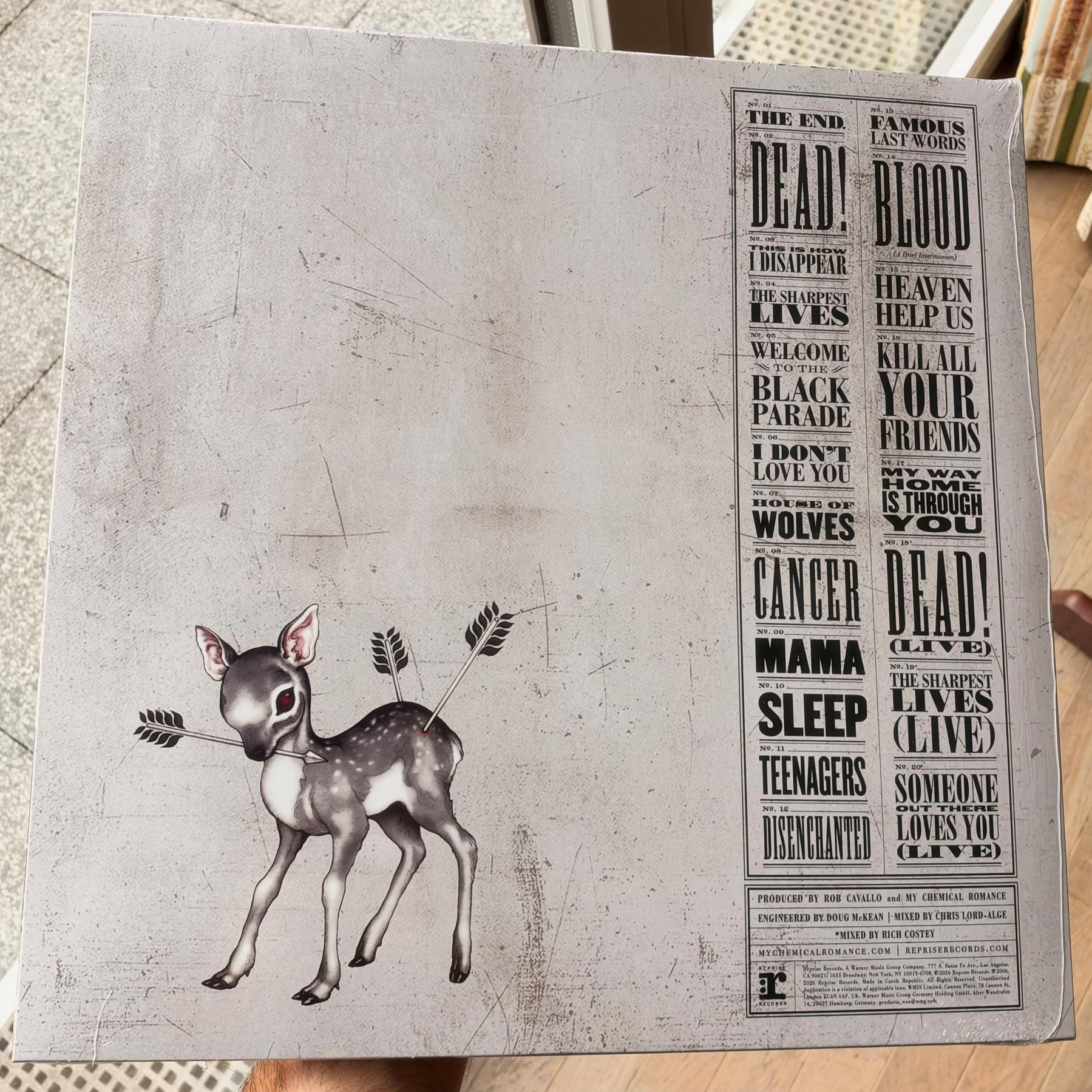A distressed illustration of a small deer with arrows in its side stands beside a column of text featuring phrases like THE END, DEAD!, BLACK PARADE, and SOMEONE LOVES YOU (LIVE).