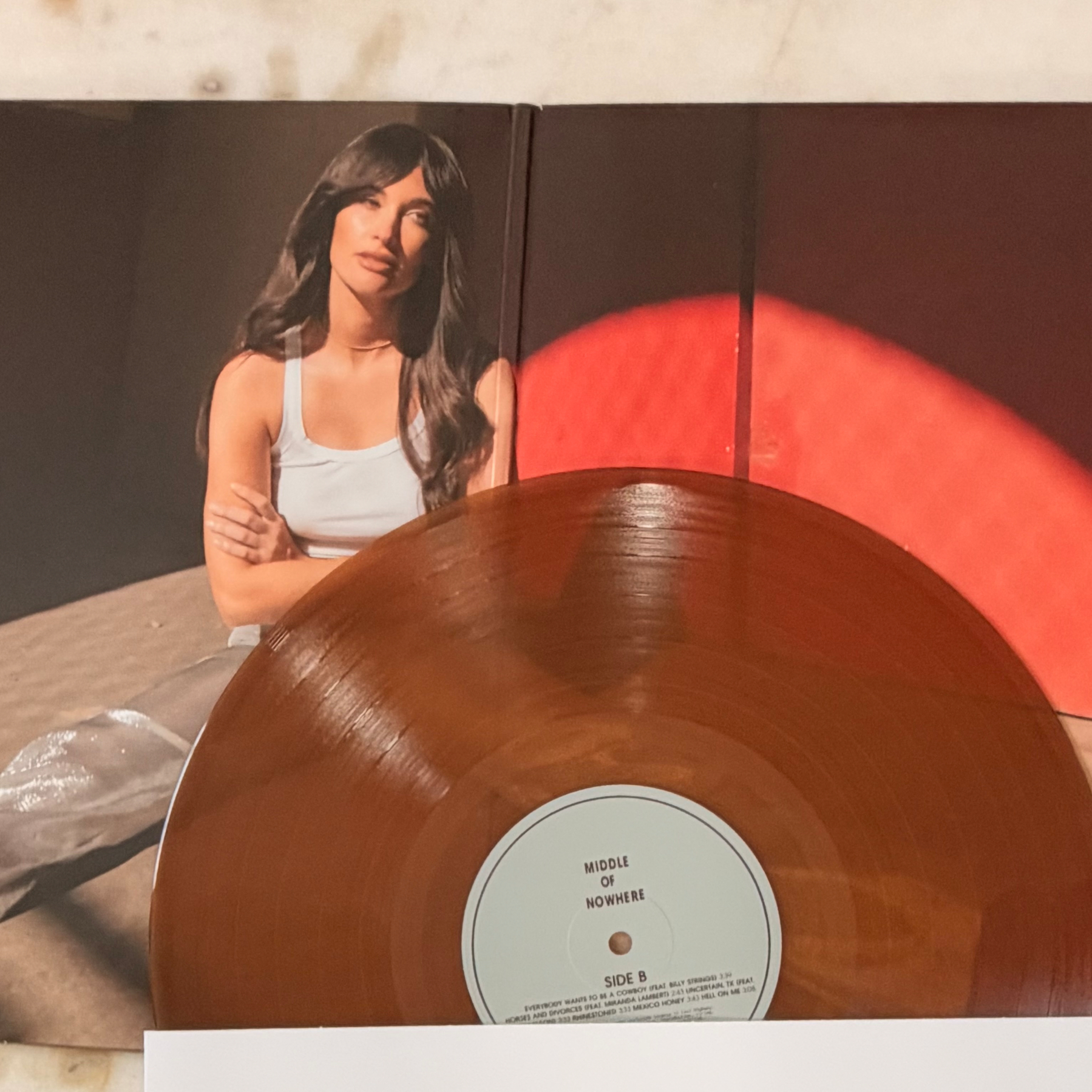 Auto-generated description: A vinyl record titled Middle of Nowhere is placed on an open album cover featuring a woman with long dark hair wearing a white tank top, sitting with her arms crossed.